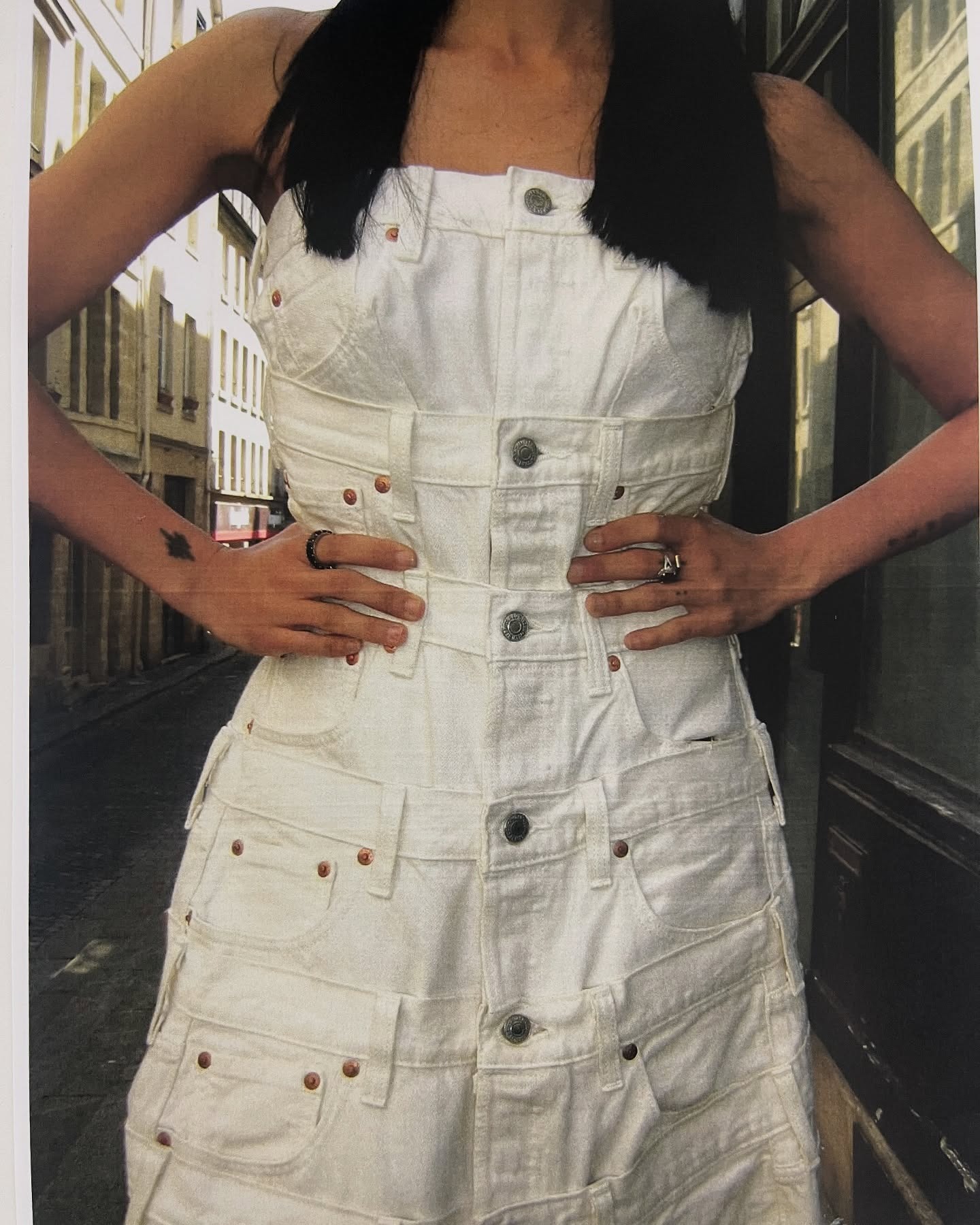 A woman wearing a white denim dress