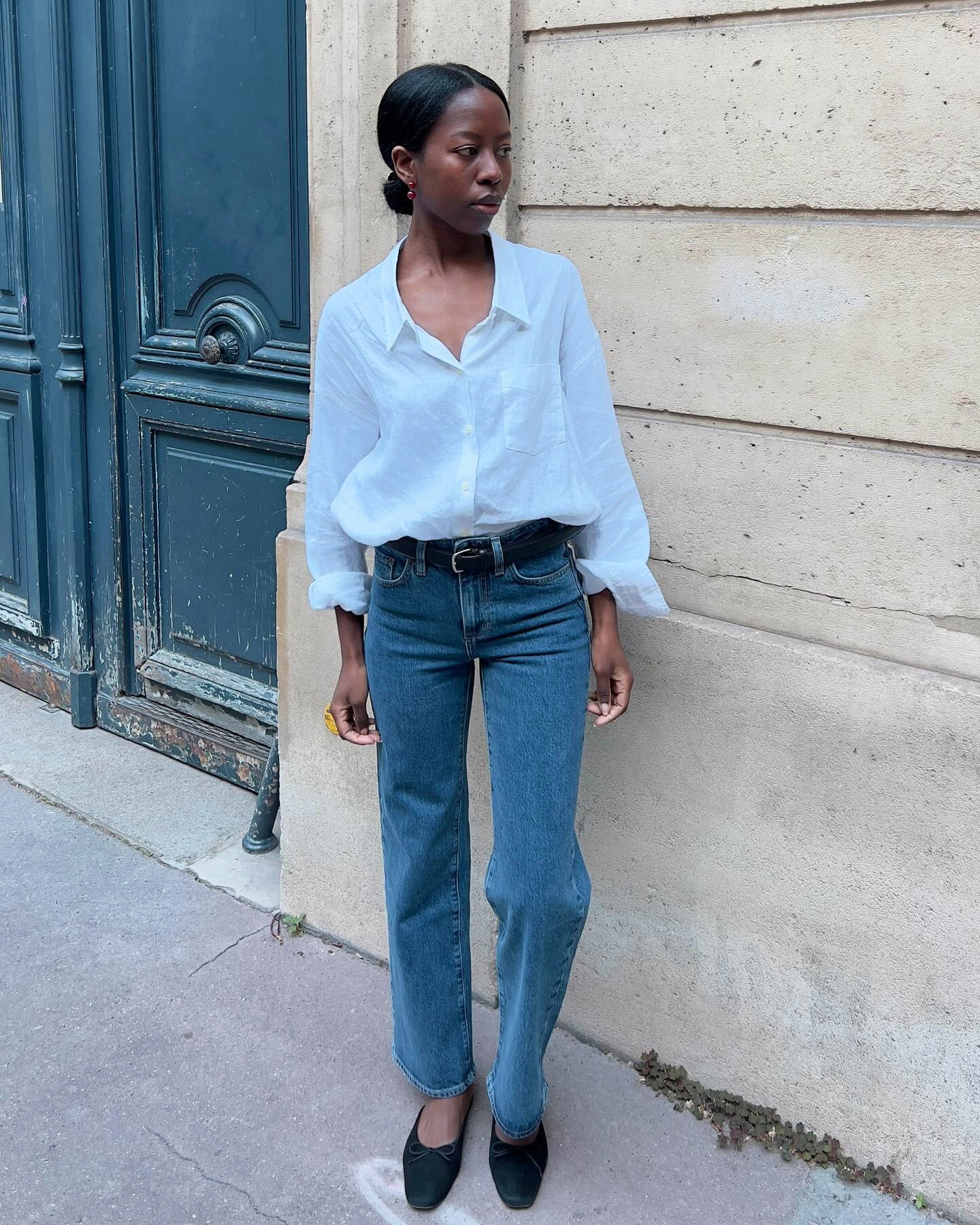 Influencer wearing a white button-down shirt with jeans.
