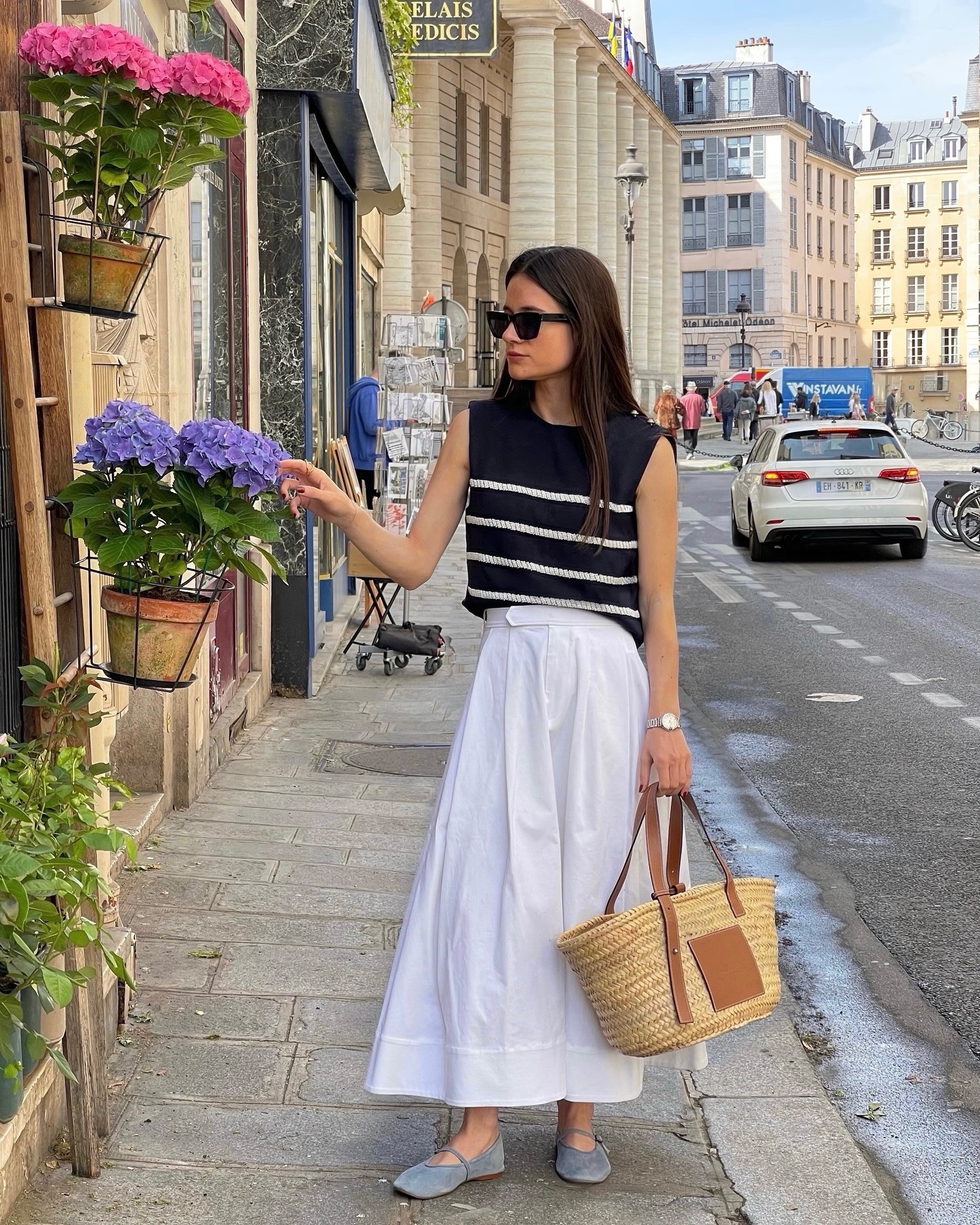 Influencer wearing a striped sweater tank and long white skirt.