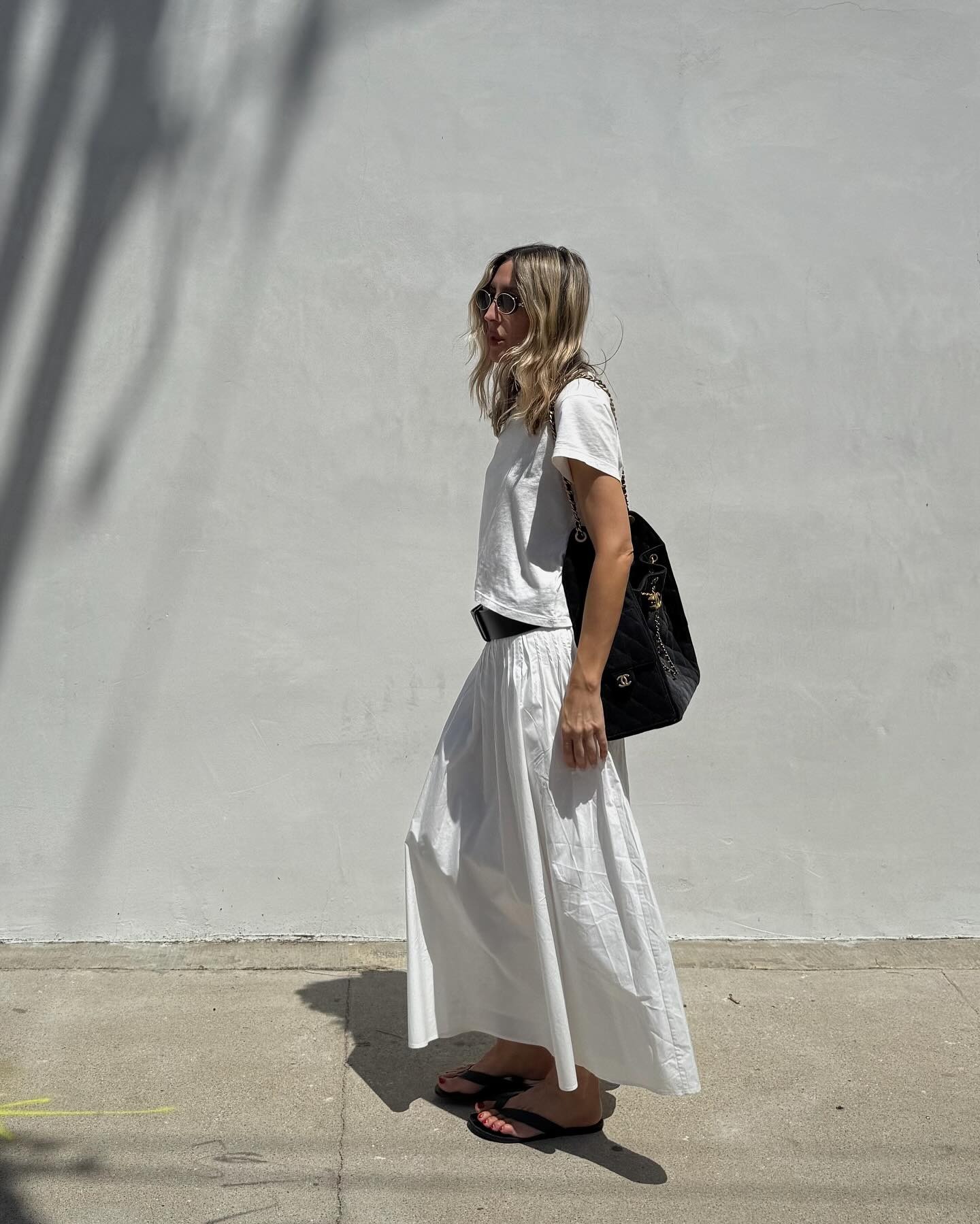 Influencer wearing a white T-shirt and long skirt.