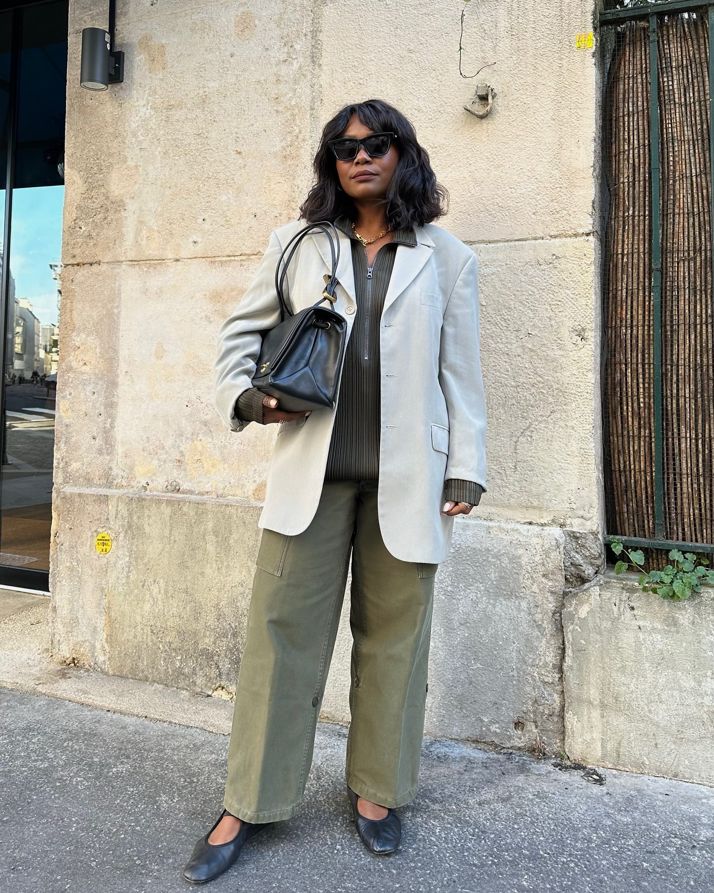 A French woman wearings black ballet flats with green cargo pants.