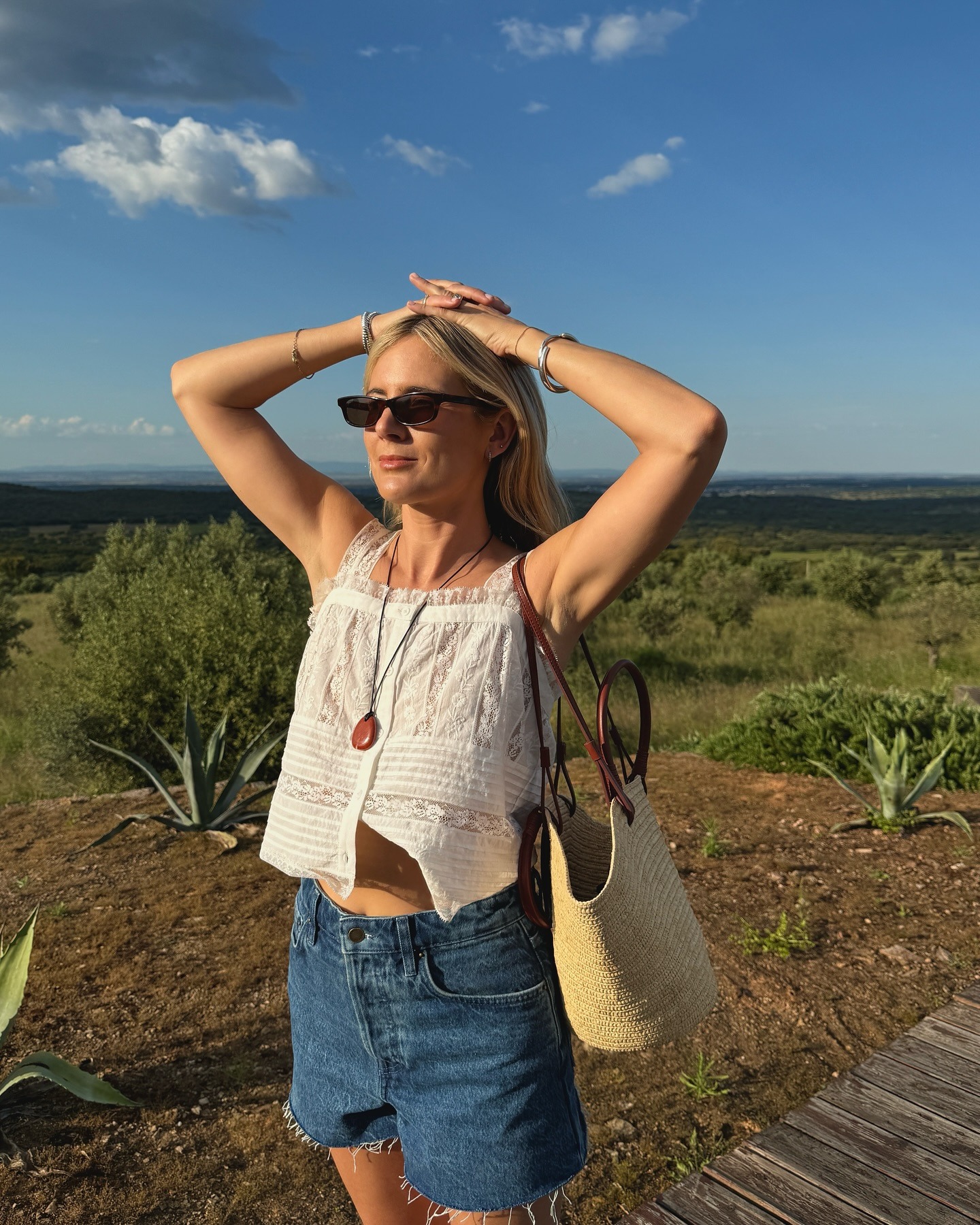 Influencer wearing a white top and denim shorts.