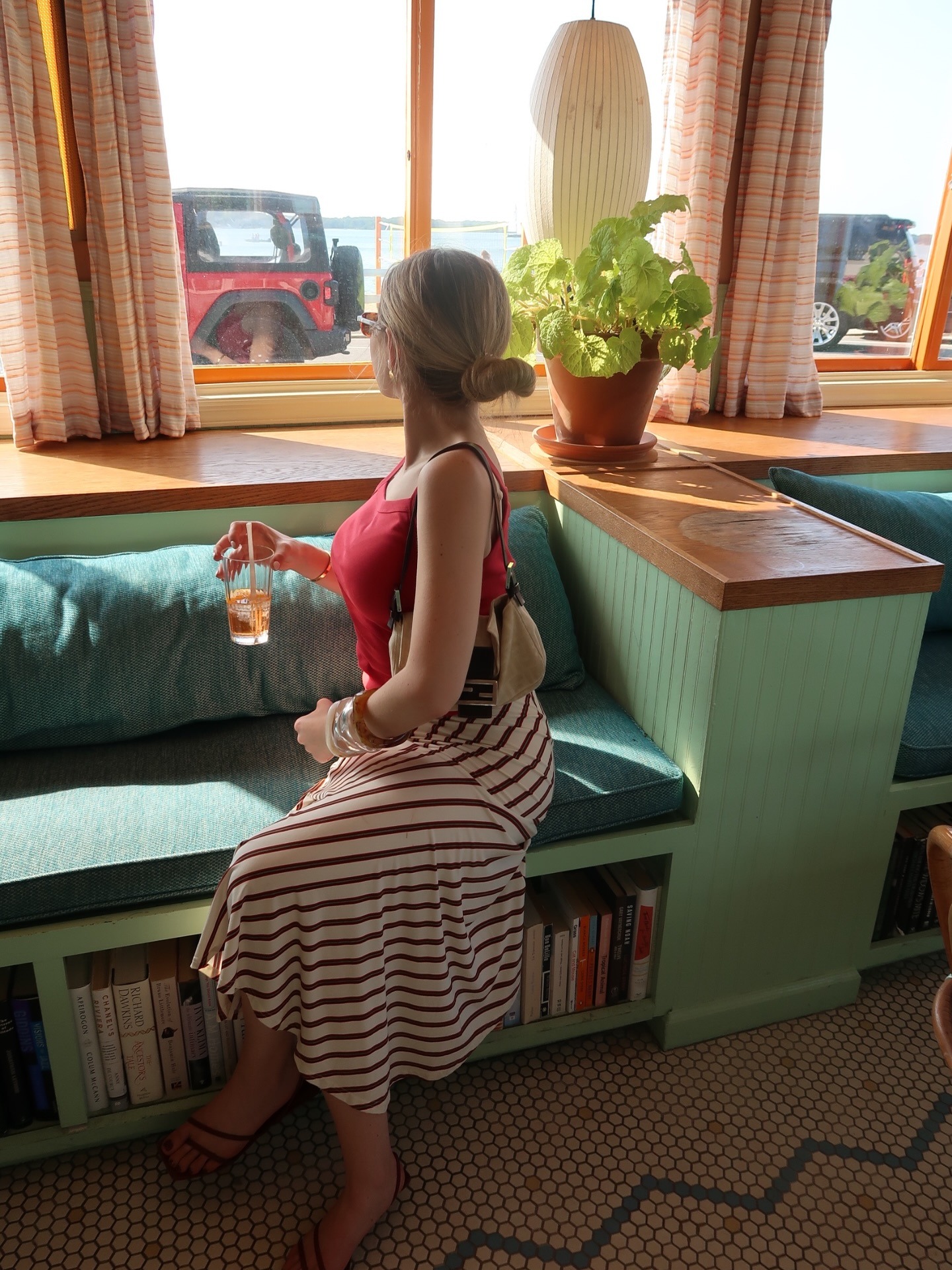Zoe wears a red tank, and stripe skirt.