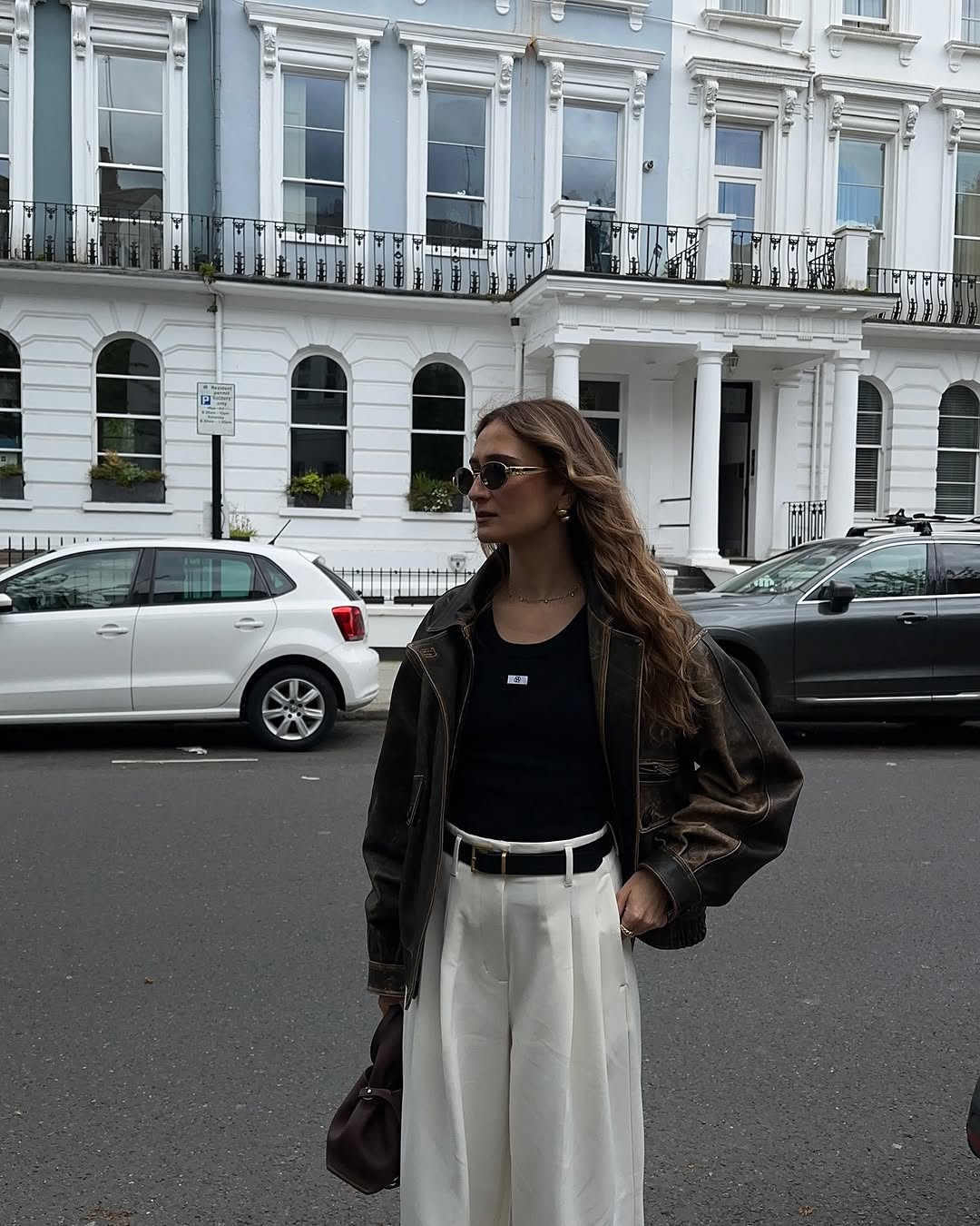 woman wearing white trousers black belt fall outfits 2025