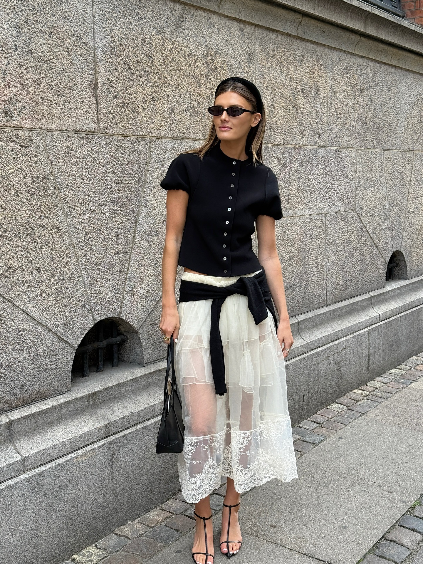 Fashion influencer wearing a cardigan-and-skirt outfit.