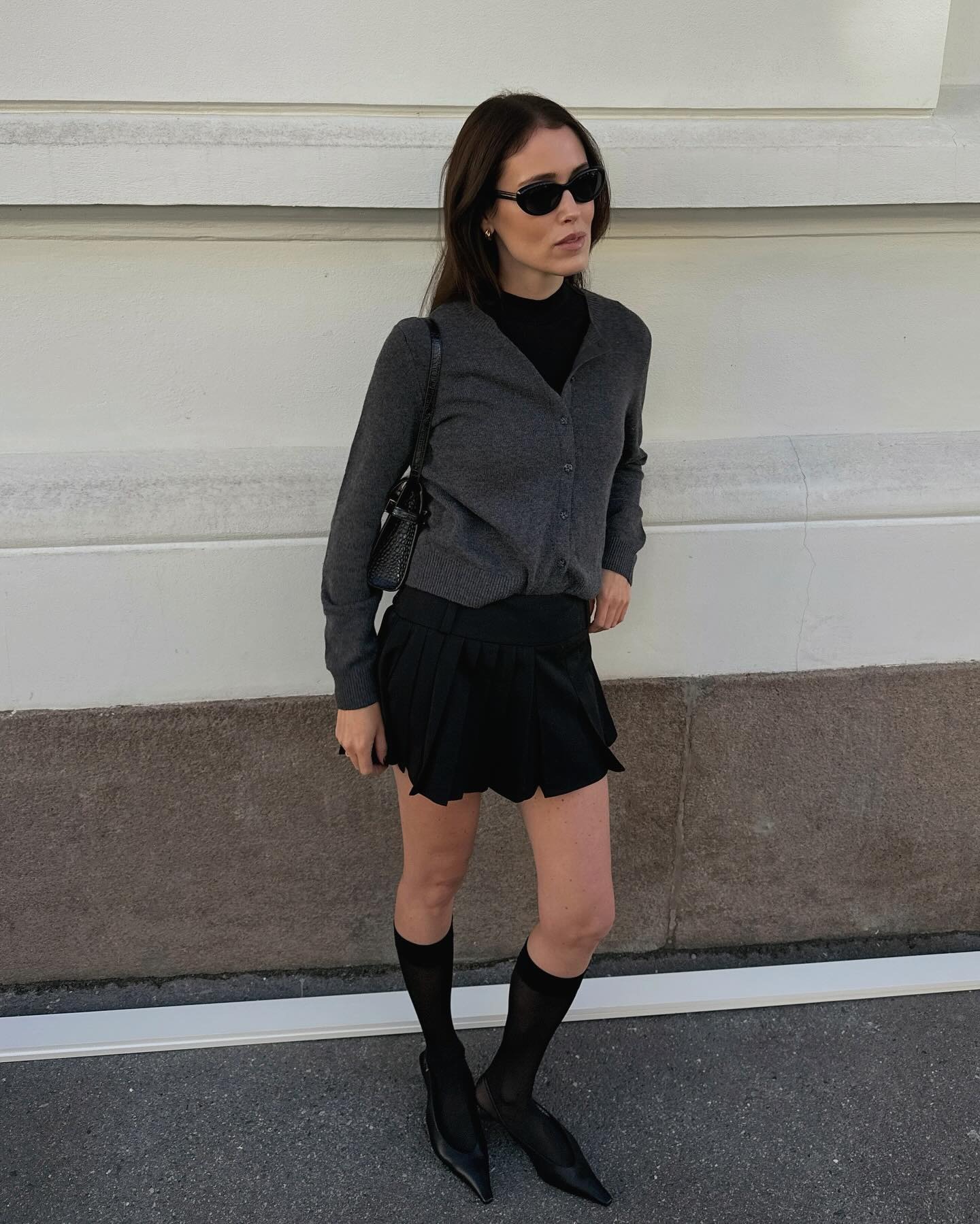Fashion influencer wearing a cardigan-and-skirt outfit.