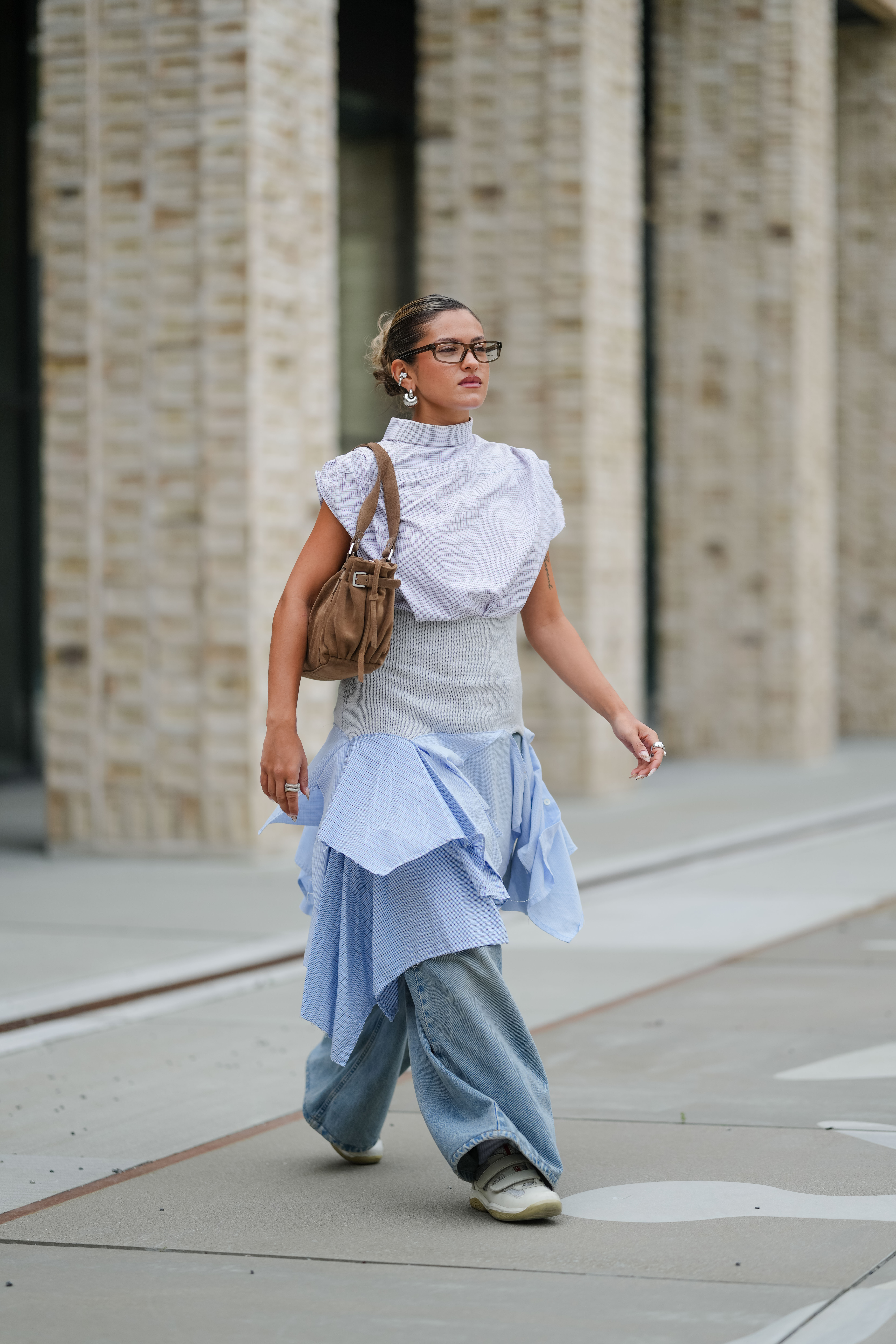Photo of Scandi woman wearing assymetrical skirt over jeans during Copenhagen Fashion Week.