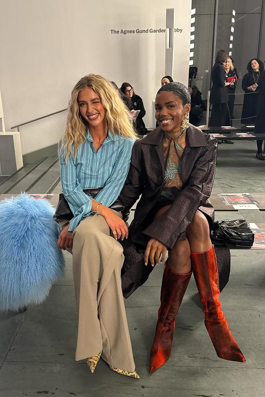 A woman wearing a blue striped shirt, khaki pants, and snakeskin boots