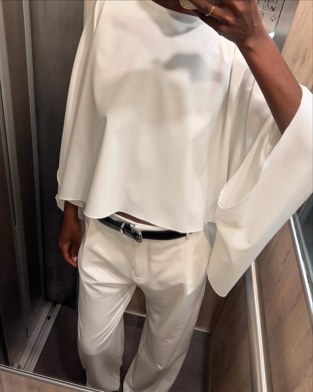 woman wearing white trousers black belt fall outfits 2025