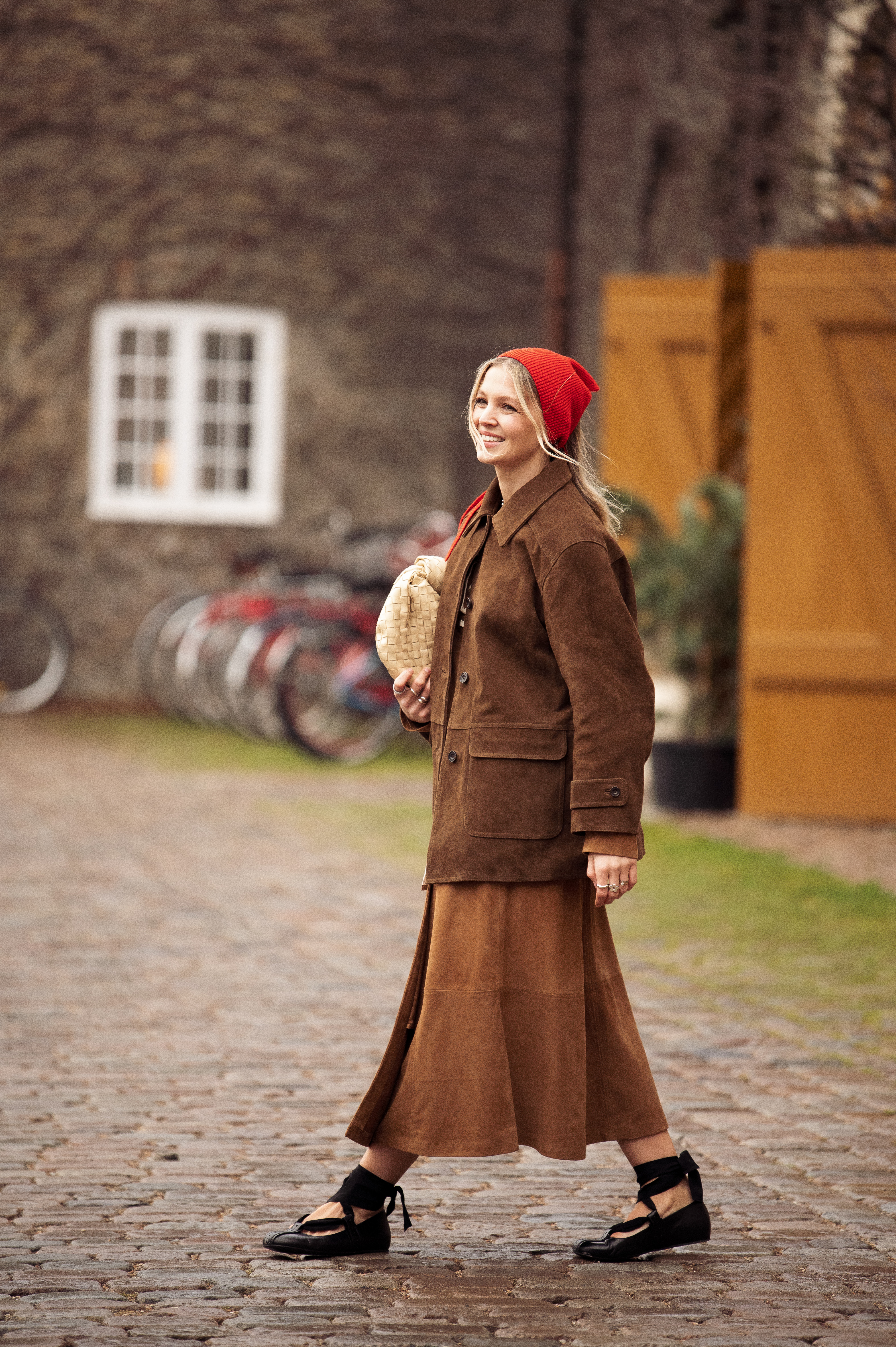 A woman wears a brown suede jacket.