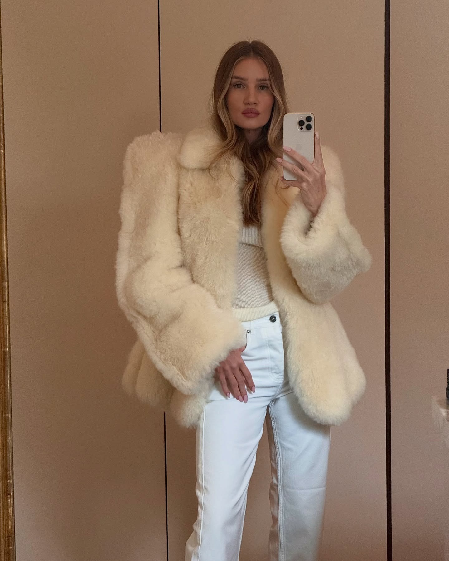 Rosie Huntington-Whiteley wearing a fur coat and white jeans.