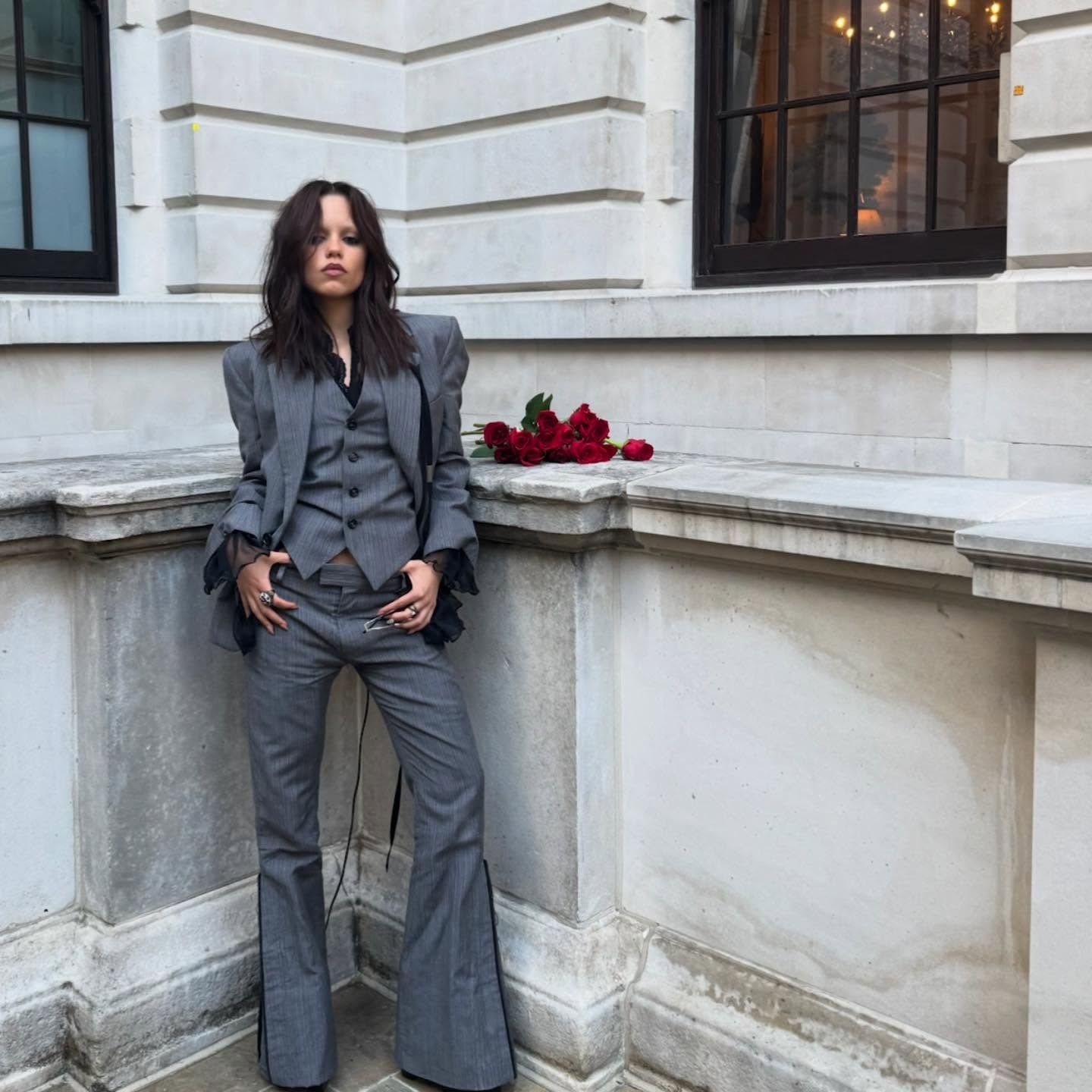 Jenna Ortega wearing a gray three-piece suit.
