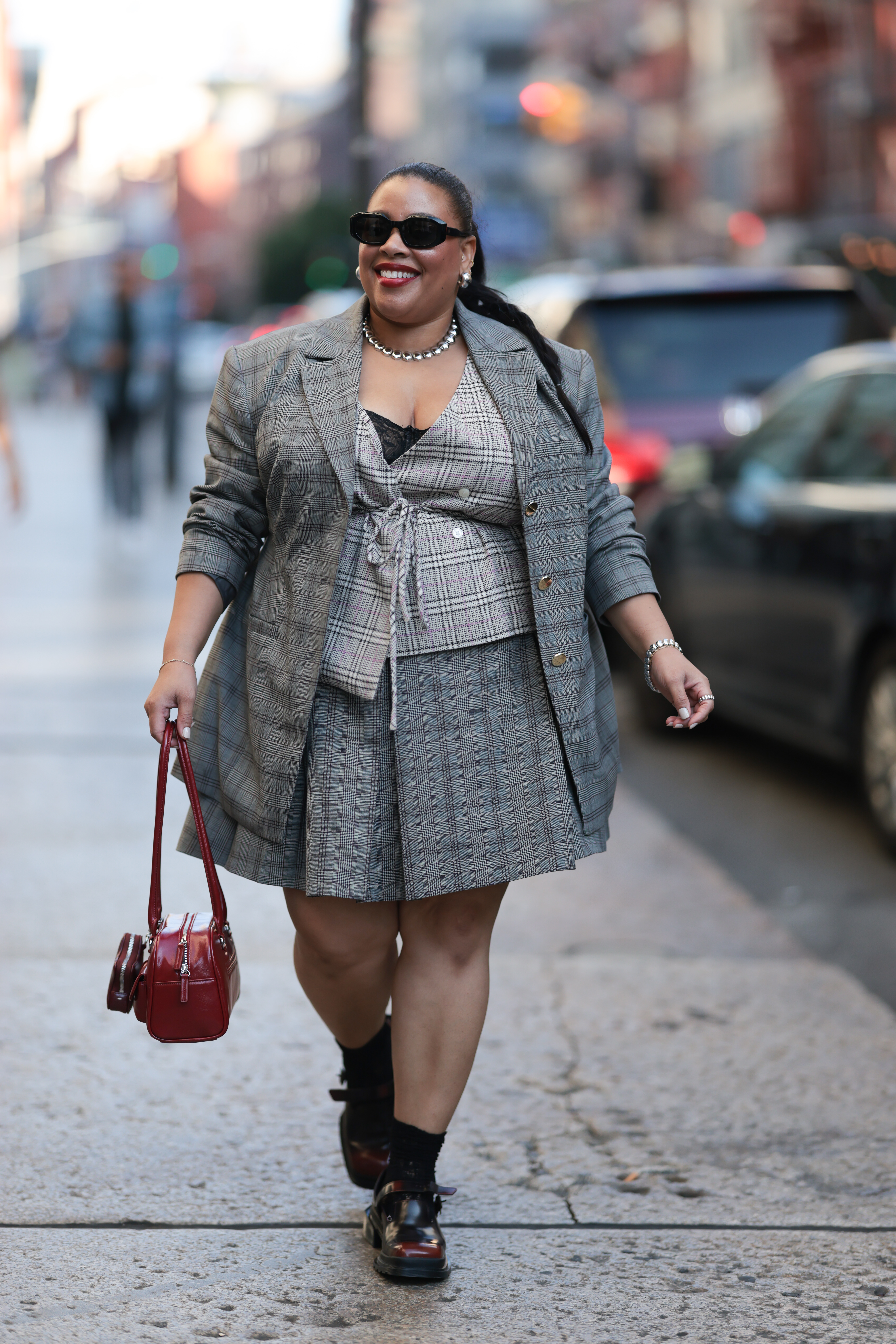 A woman wears a checkered blazer.
