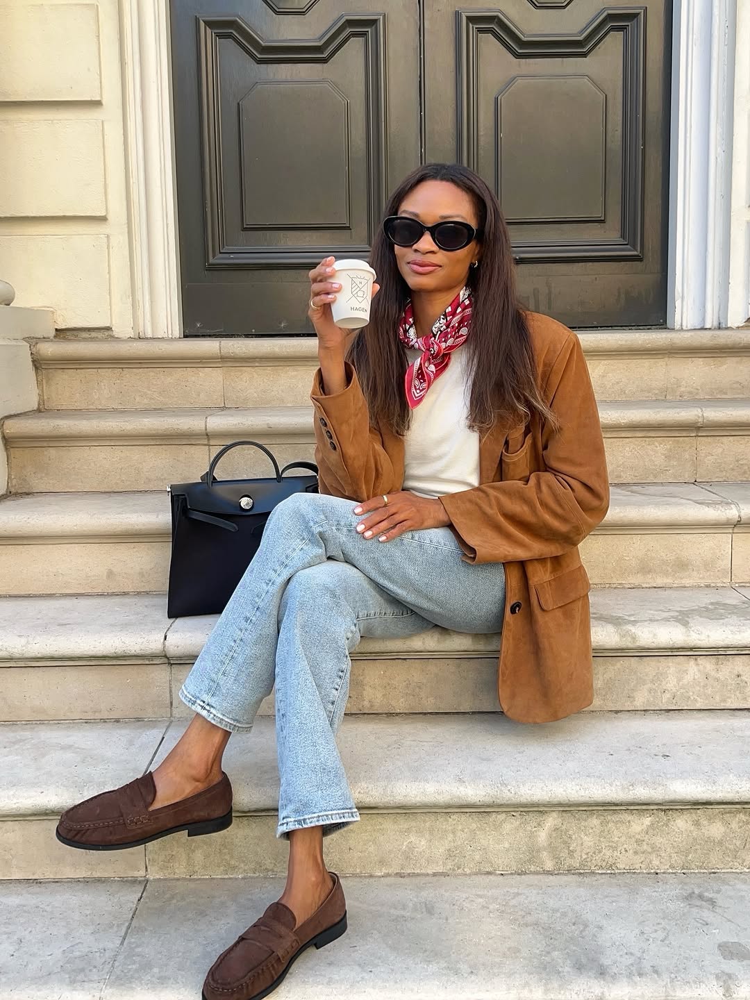 Woman wearing a tan jacket with jeans in a fall 2025 outfit.