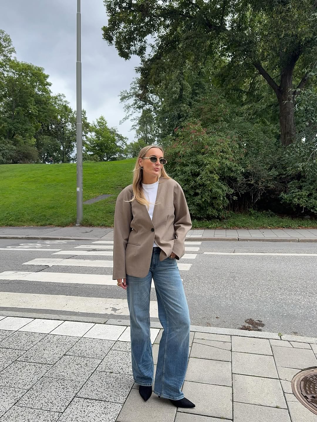 Woman wearing a tan jacket with jeans in a fall 2025 outfit.