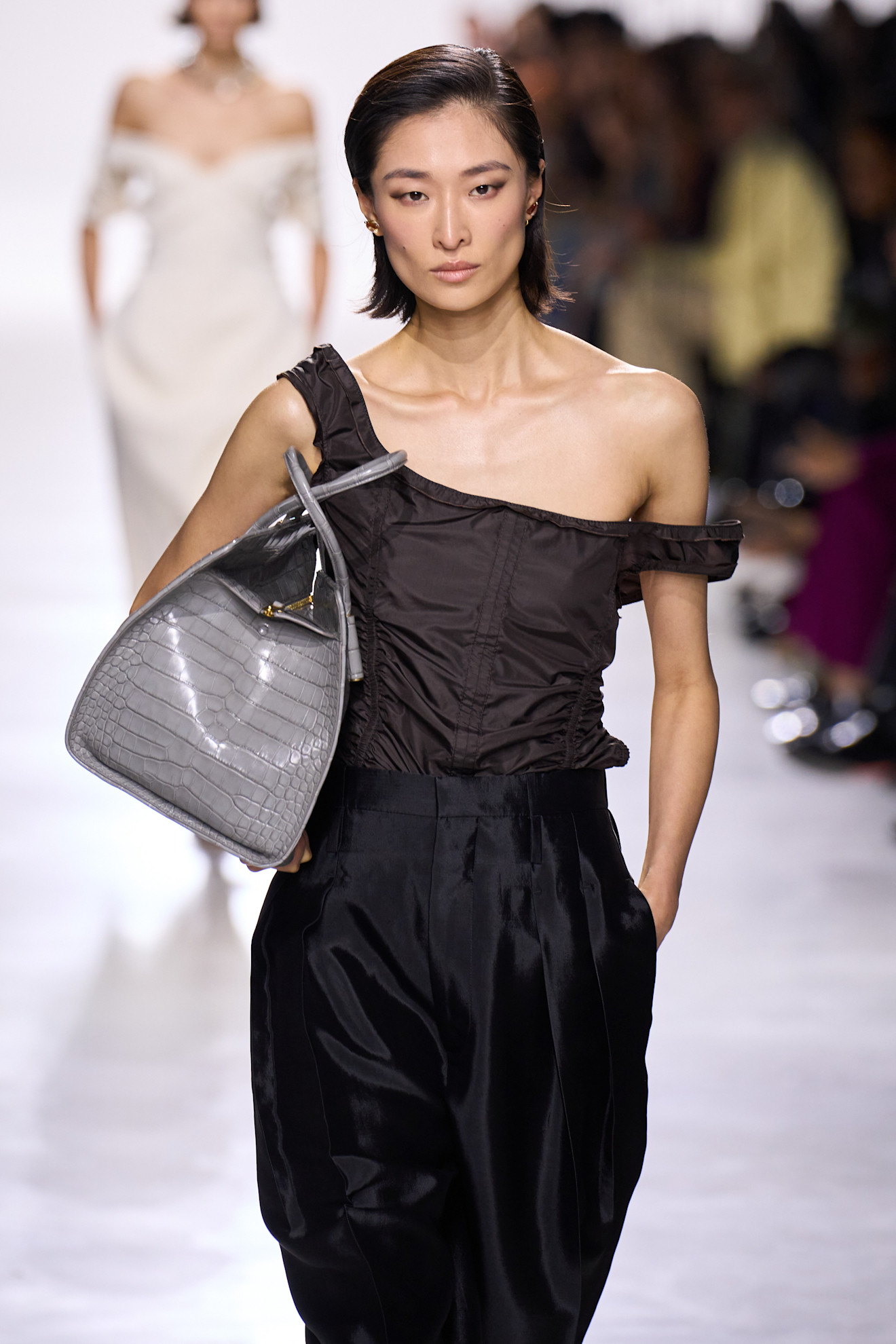 Close-up images of a model at the S/S 26 Bottega Veneta show wearing gray.