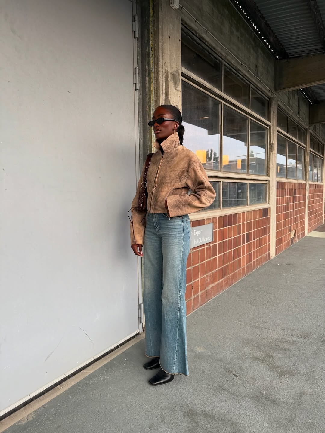 Woman wearing a tan jacket with jeans in a fall 2025 outfit.