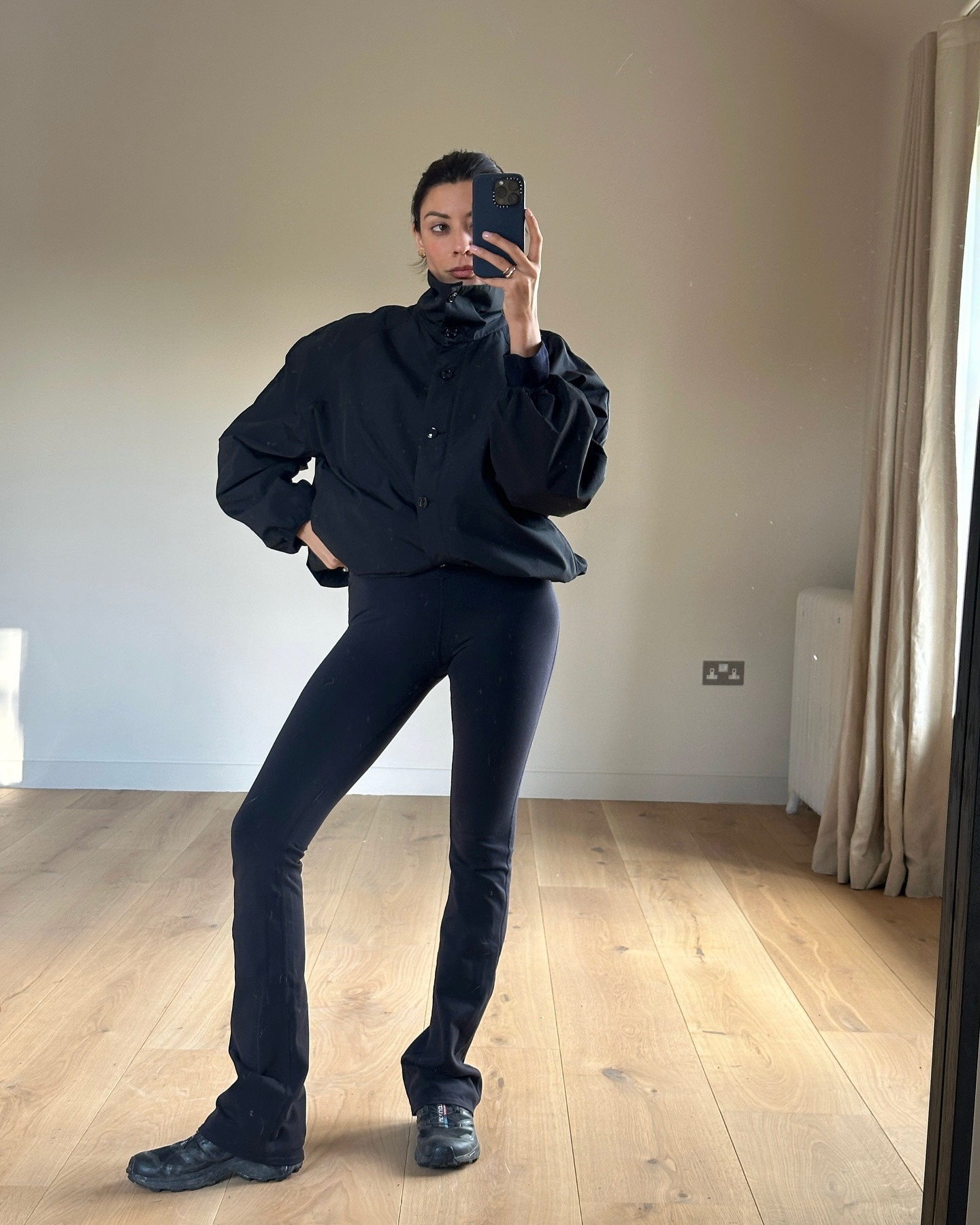 Influencer wearing leggings with a windbreaker and black sneakers