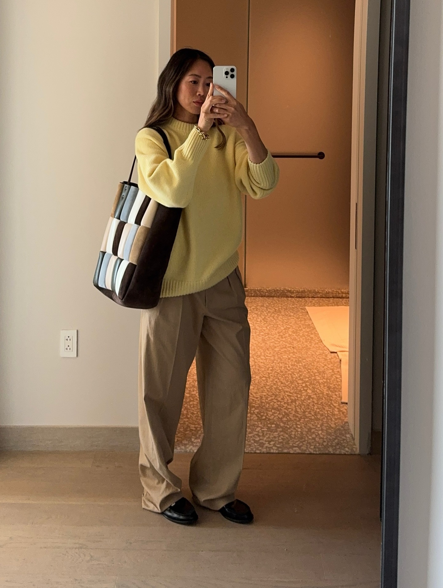 Aimee Song wearing a yellow sweater and khaki pants