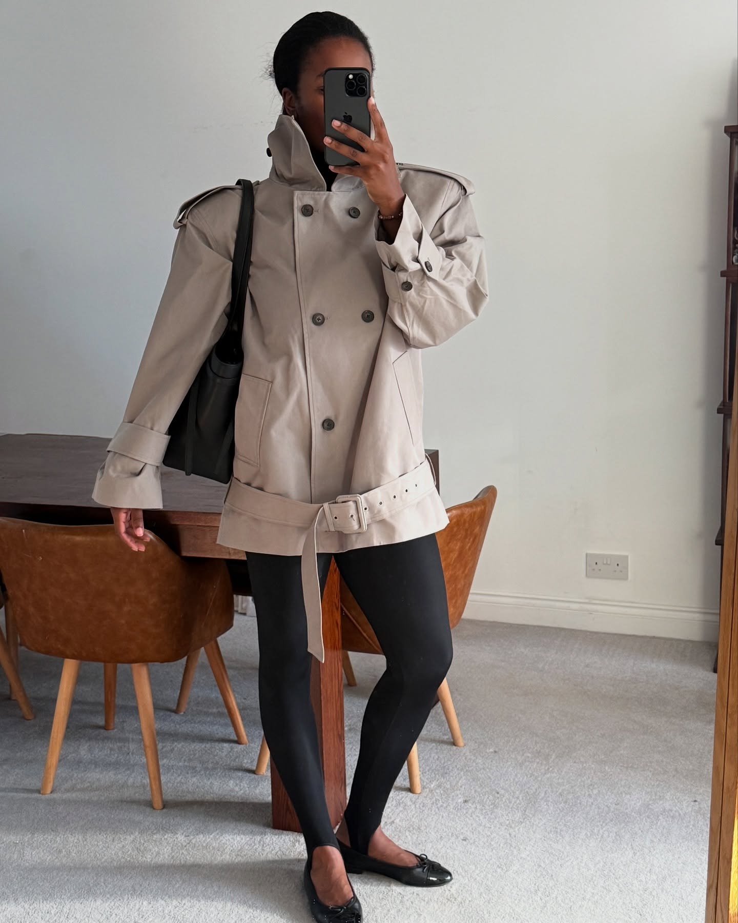 Influencer wearing a trench coat, leggings, and ballet flats