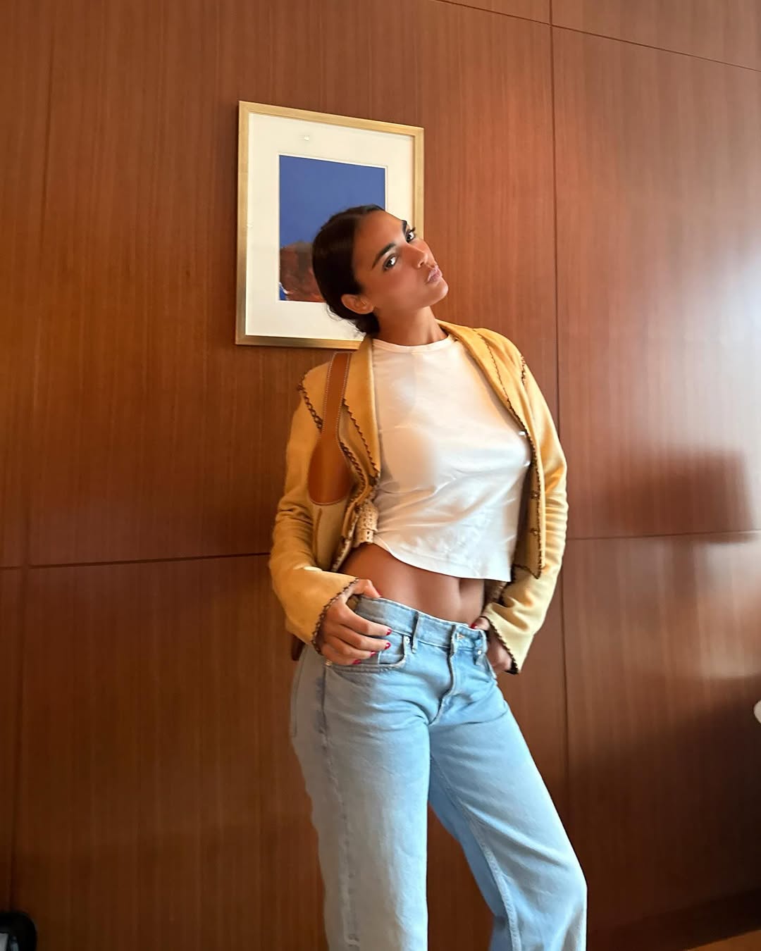 Woman wearing a tan jacket with jeans in a fall 2025 outfit.