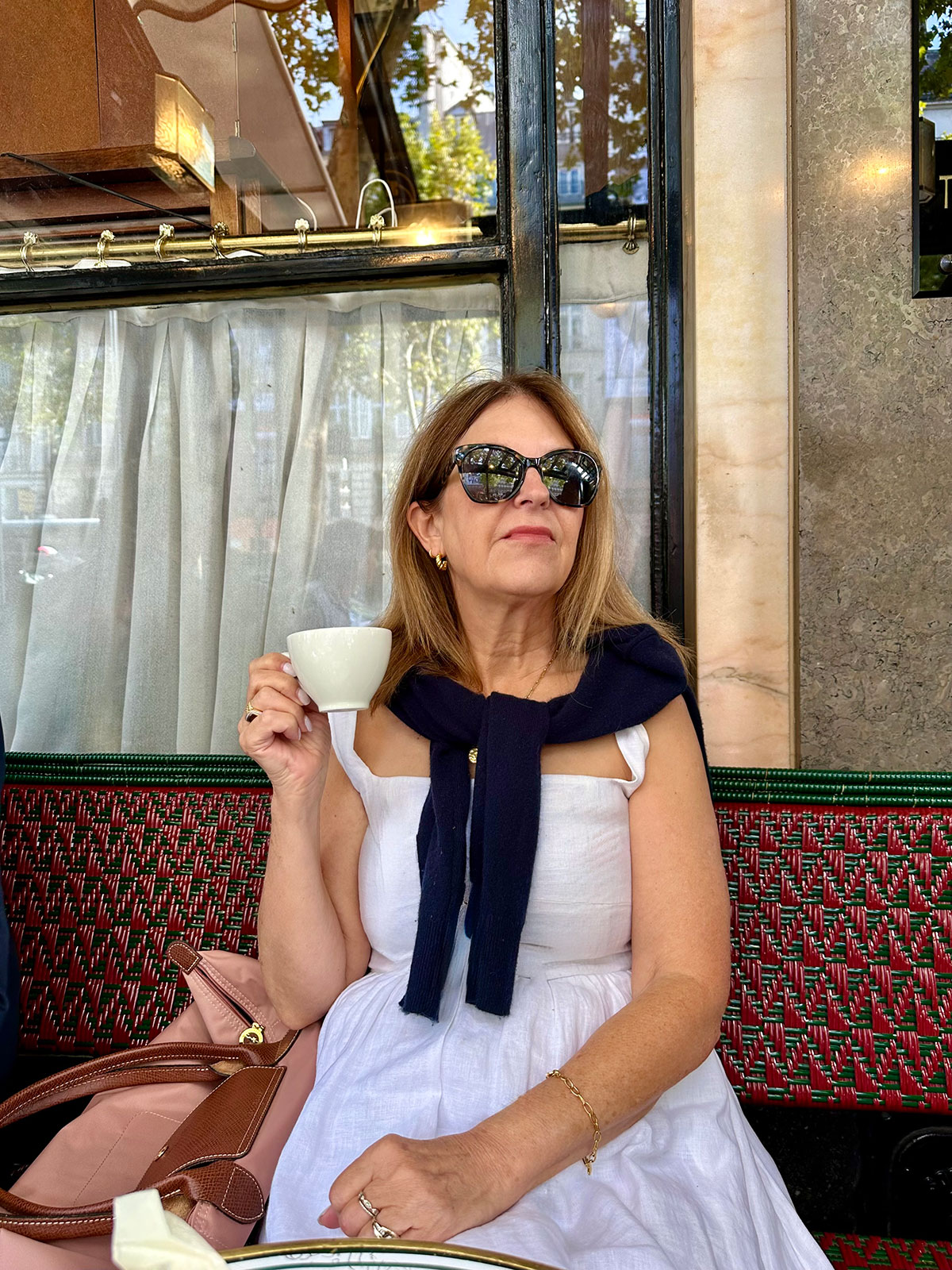 A Nordstrom stylist wearing a black cashmere sweater around her shoulders in Paris.