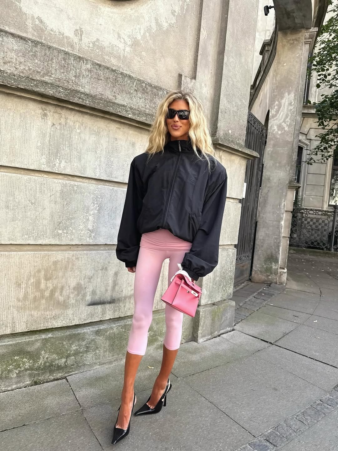 Influencer wearing pink capri leggings with a windbreakers and heels