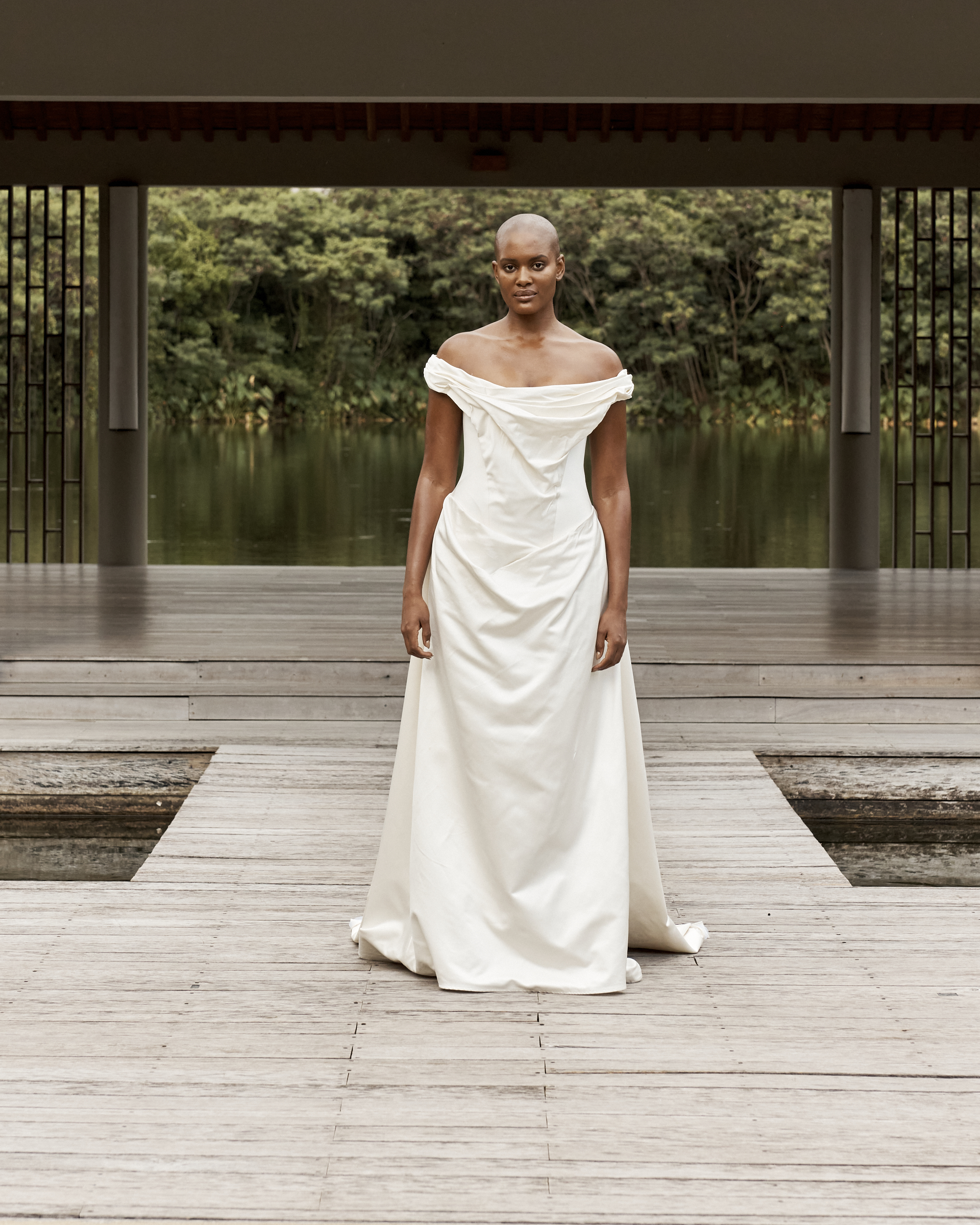 A woman wears an off the shoulder draped gown.