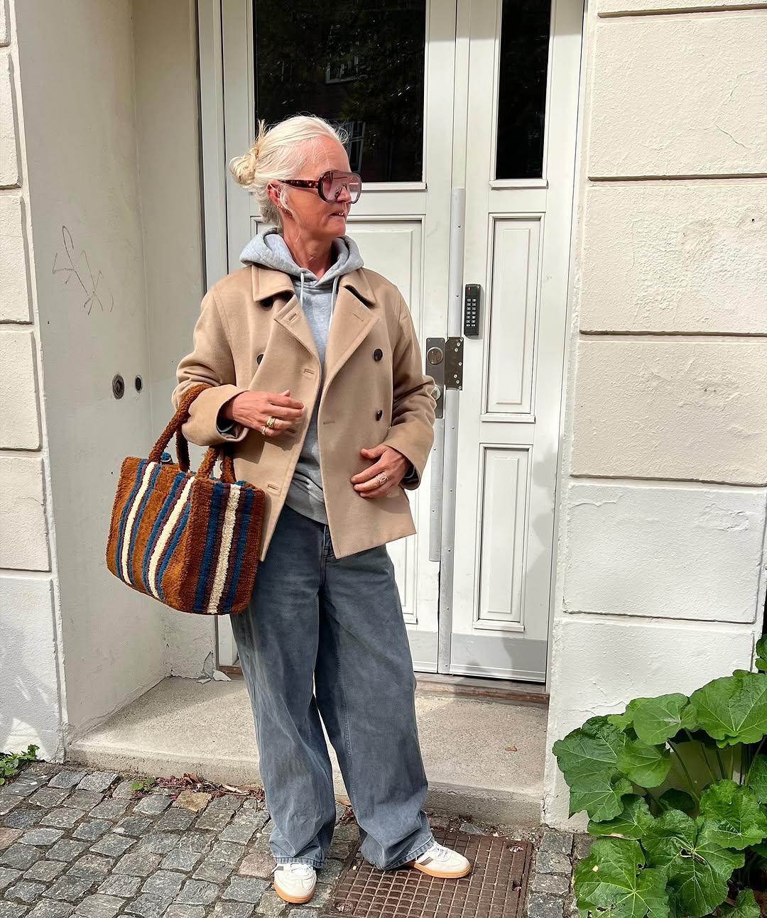 Woman wearing a tan jacket with jeans in a fall 2025 outfit.