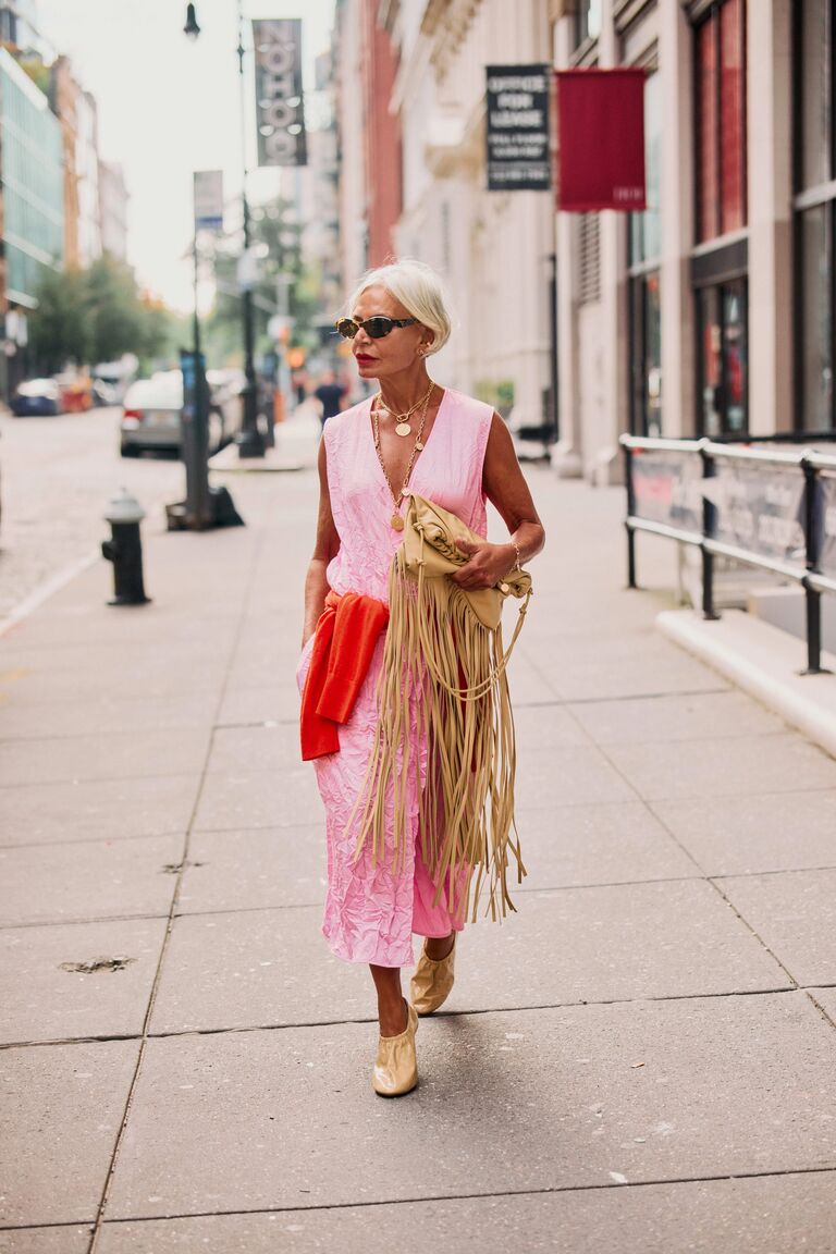 Woman wearing a red accent sweater during NYFW S/S 26.