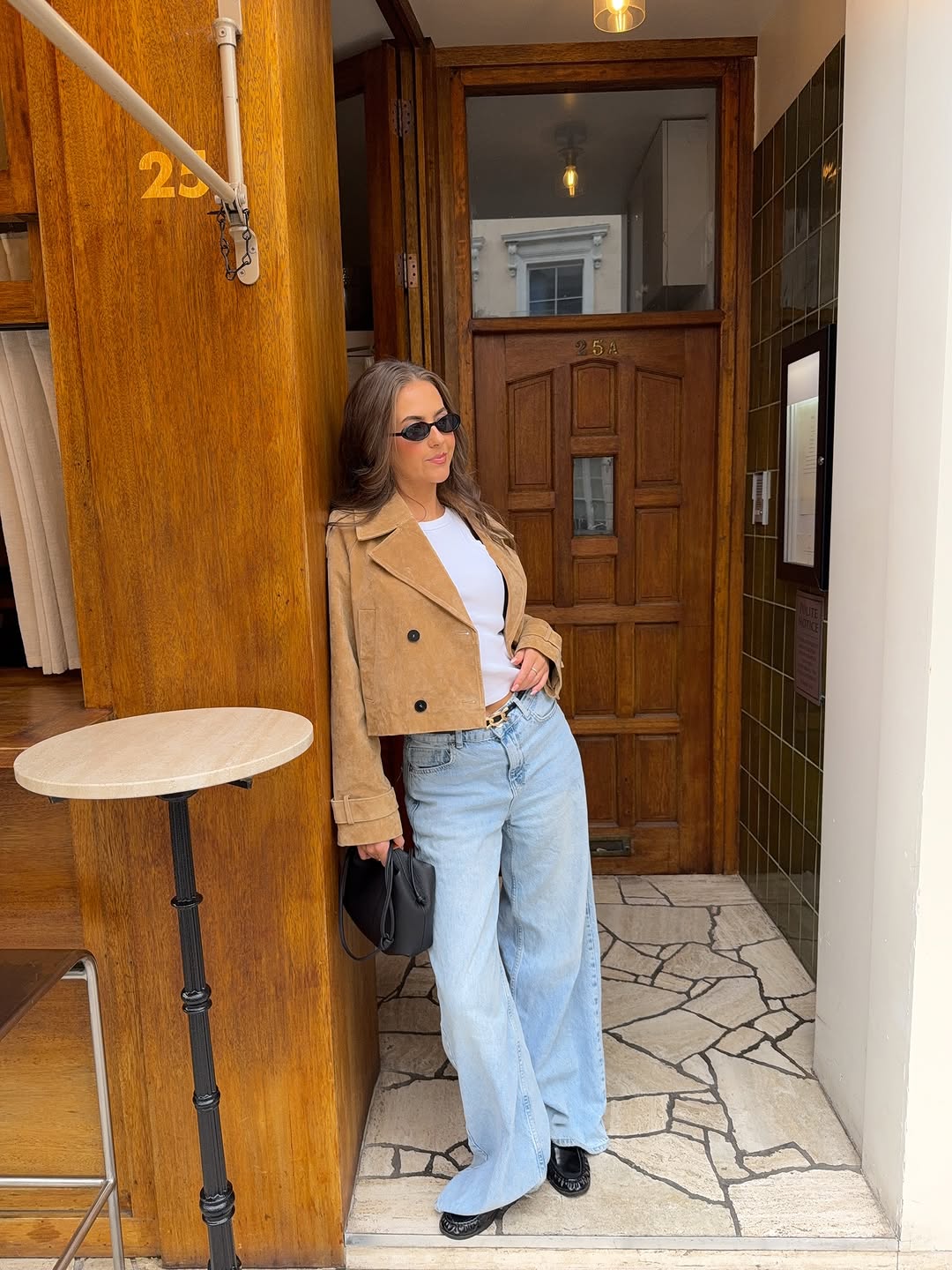woman wearing jeans with cropped tan jacket fall 2025