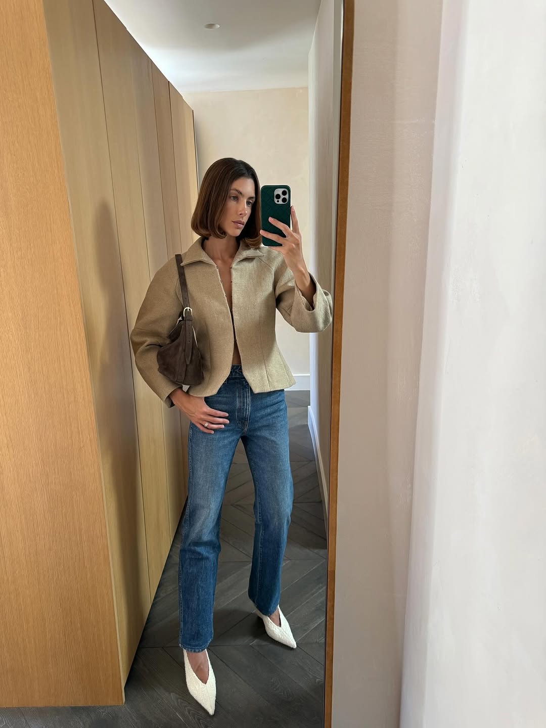 Woman wearing a tan jacket with jeans in a fall 2025 outfit.