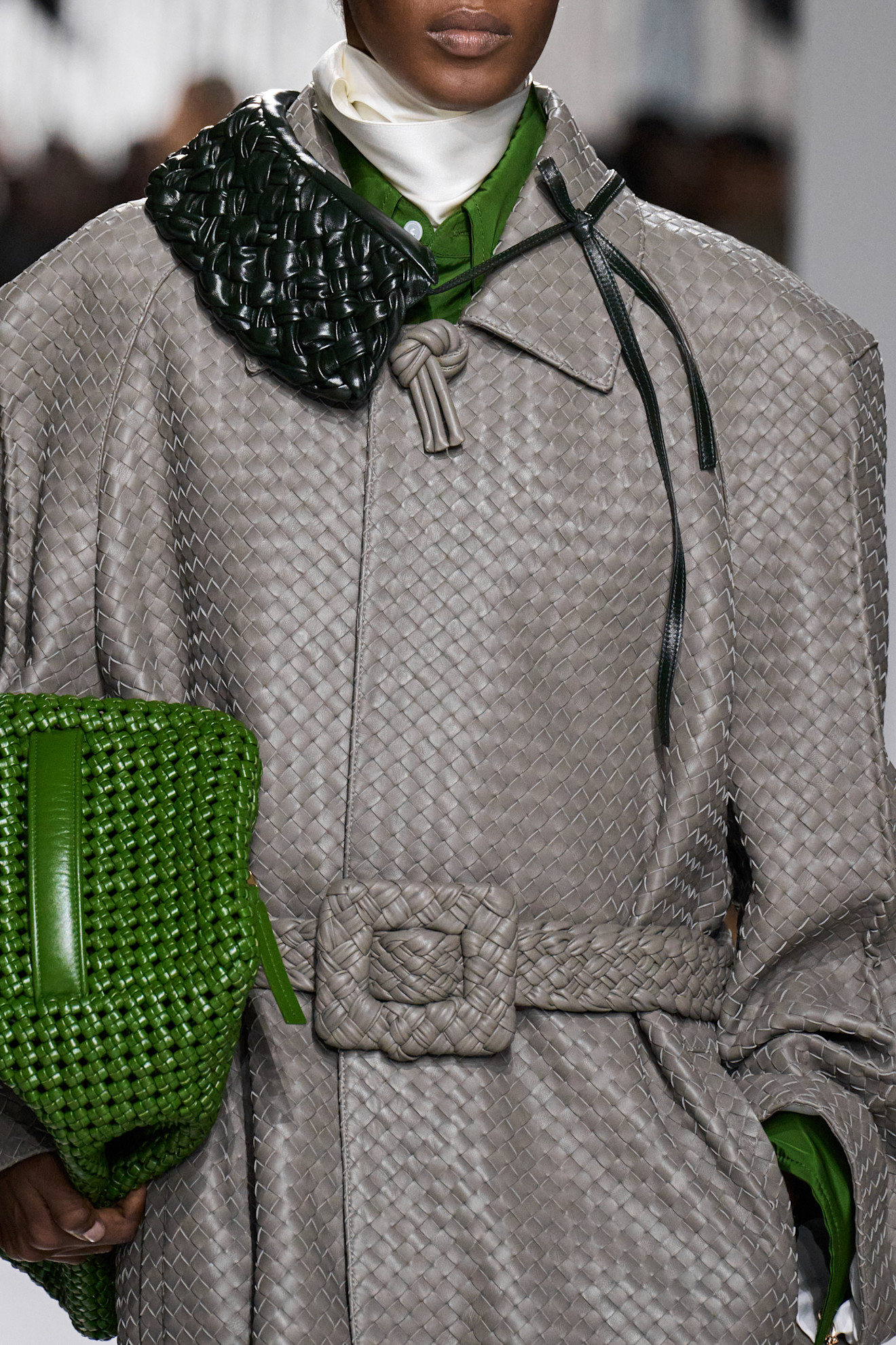 A close-up of a model at the S/S 26 Bottega Veneta show with bits of green or yellow styling.