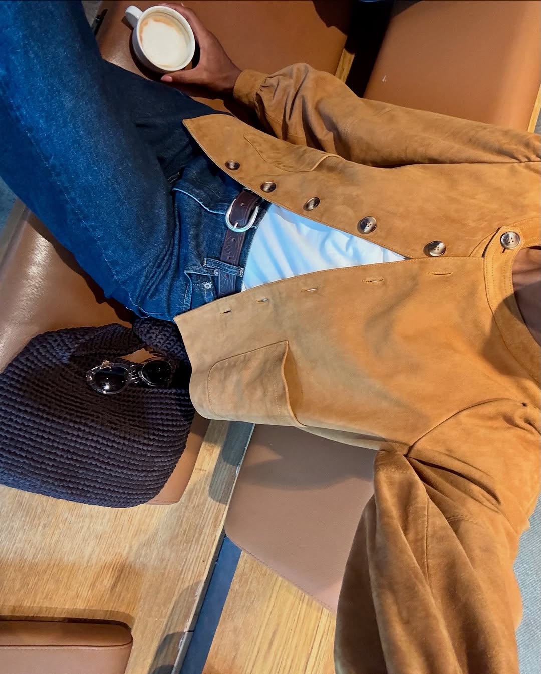 Woman wearing a tan jacket with jeans in a fall 2025 outfit.