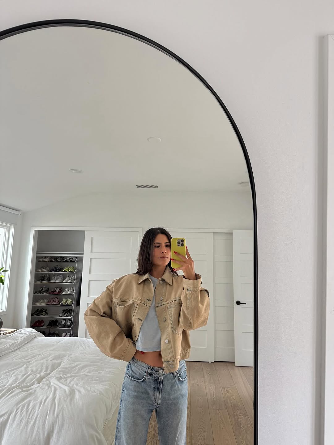 Woman wearing a tan jacket with jeans in a fall 2025 outfit.