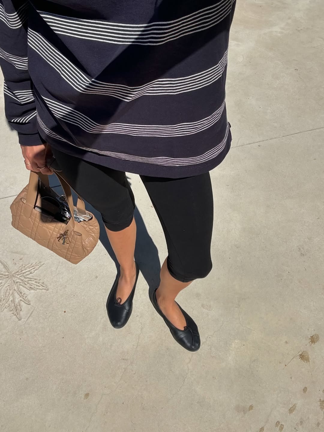 Influencer wearing capri leggings with a striped top and ballet flats