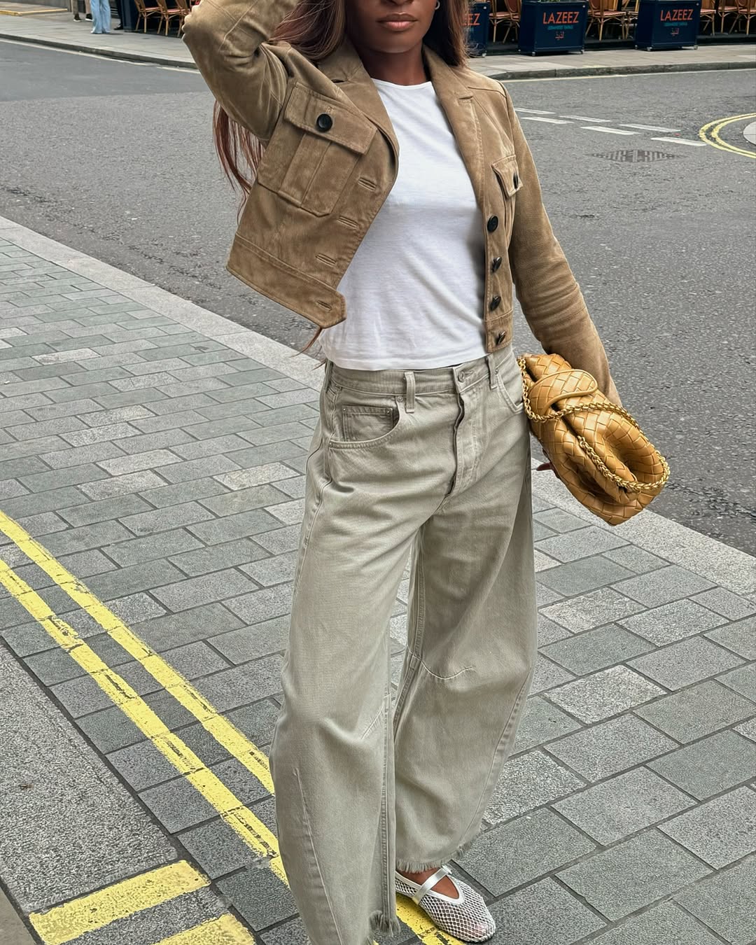 Woman wearing a tan jacket with jeans in a fall 2025 outfit.