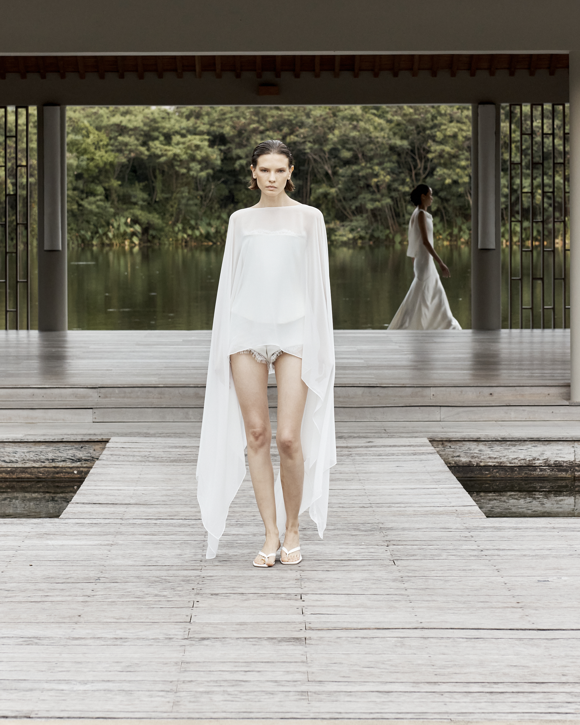 A woman wears a white cape.