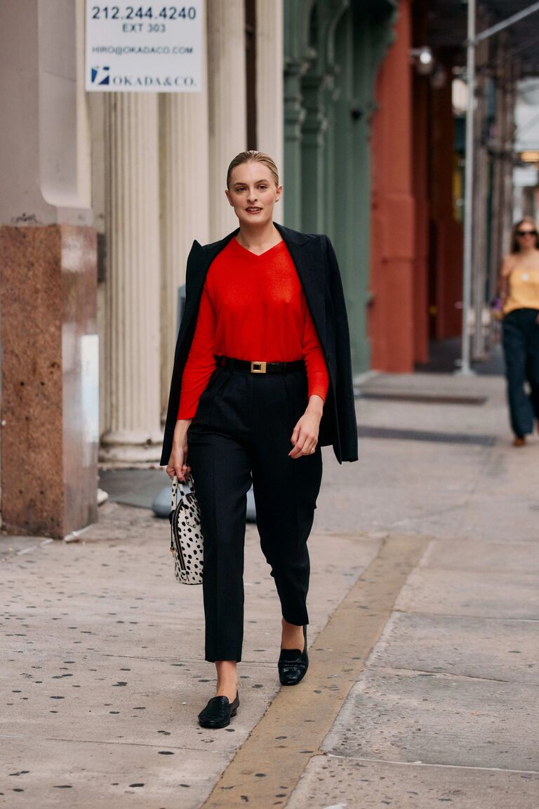 Woman wearing a red accent sweater during NYFW S/S 26.