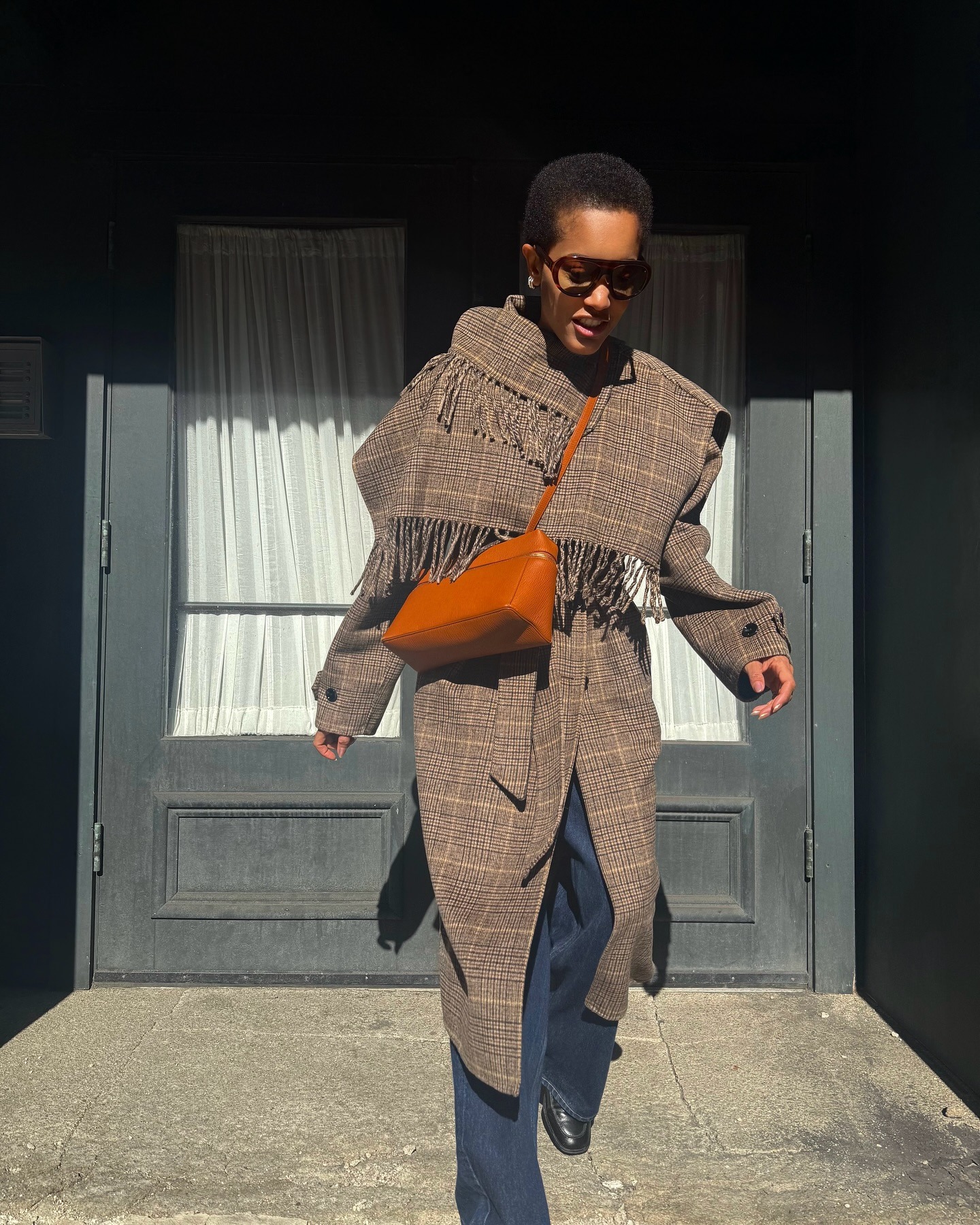 Tamu McPherson wears a plaid fringe coat.