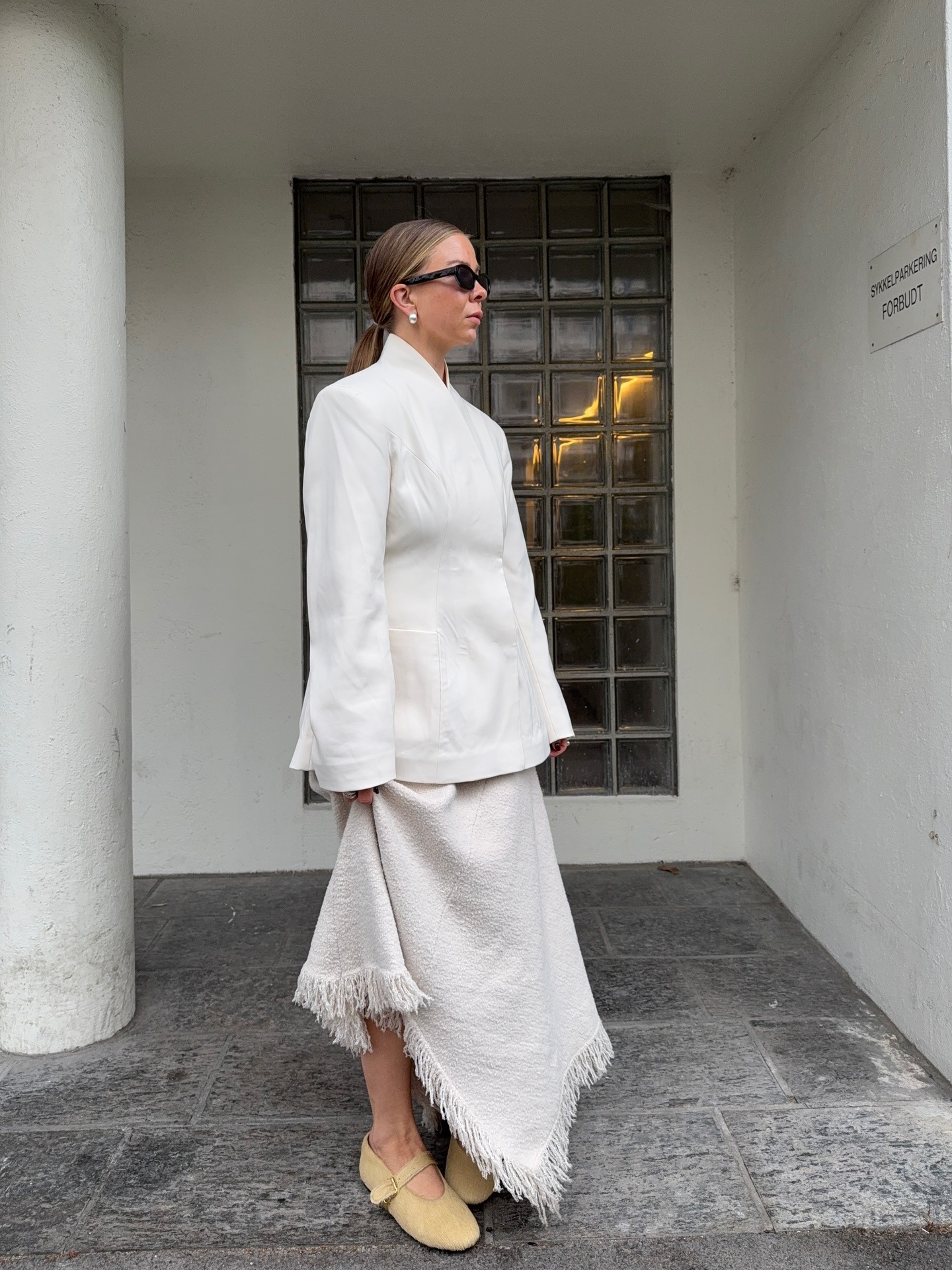 Dina wears an all white outfit with beige flats.