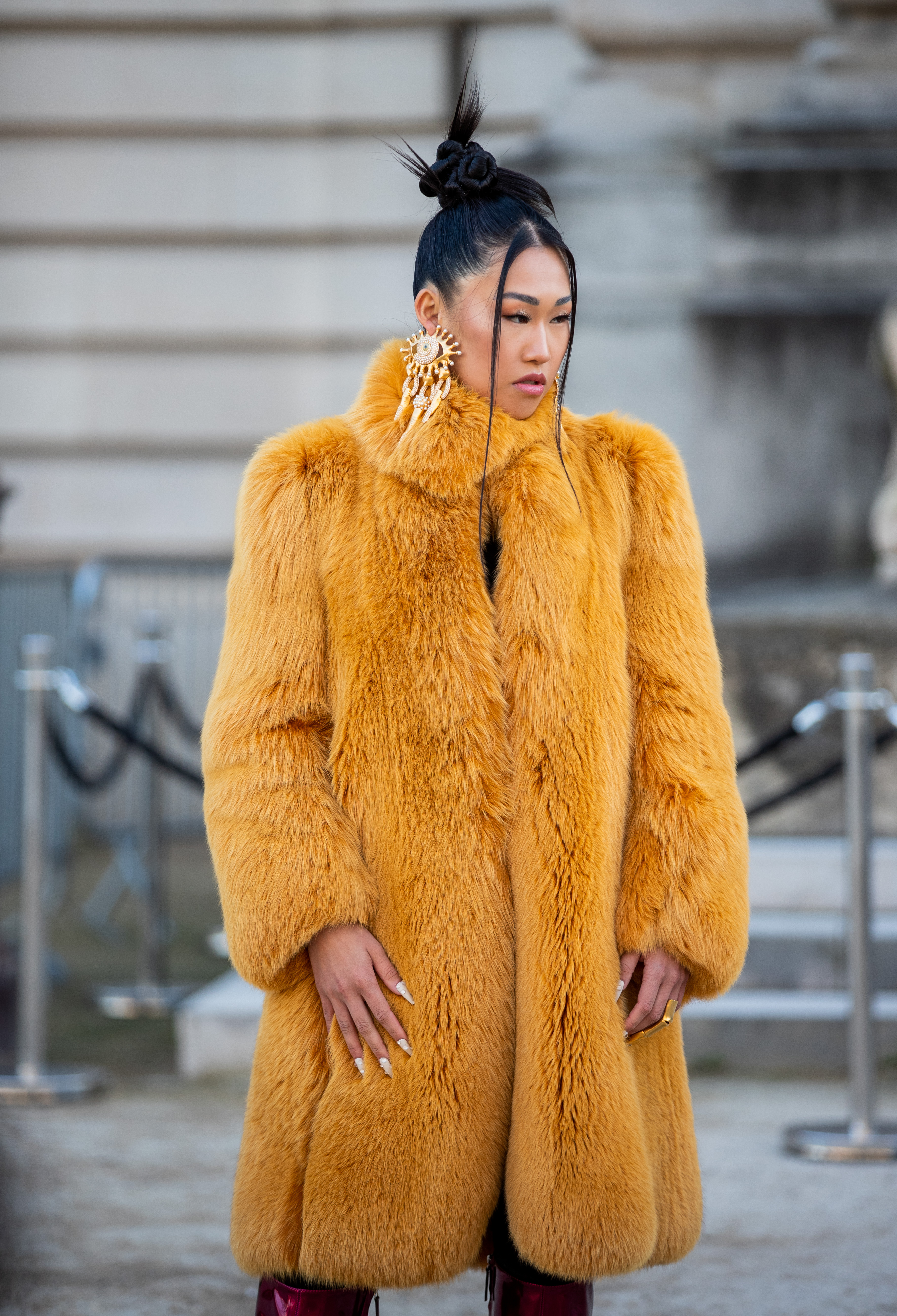 a woman wears a yellow fur coat