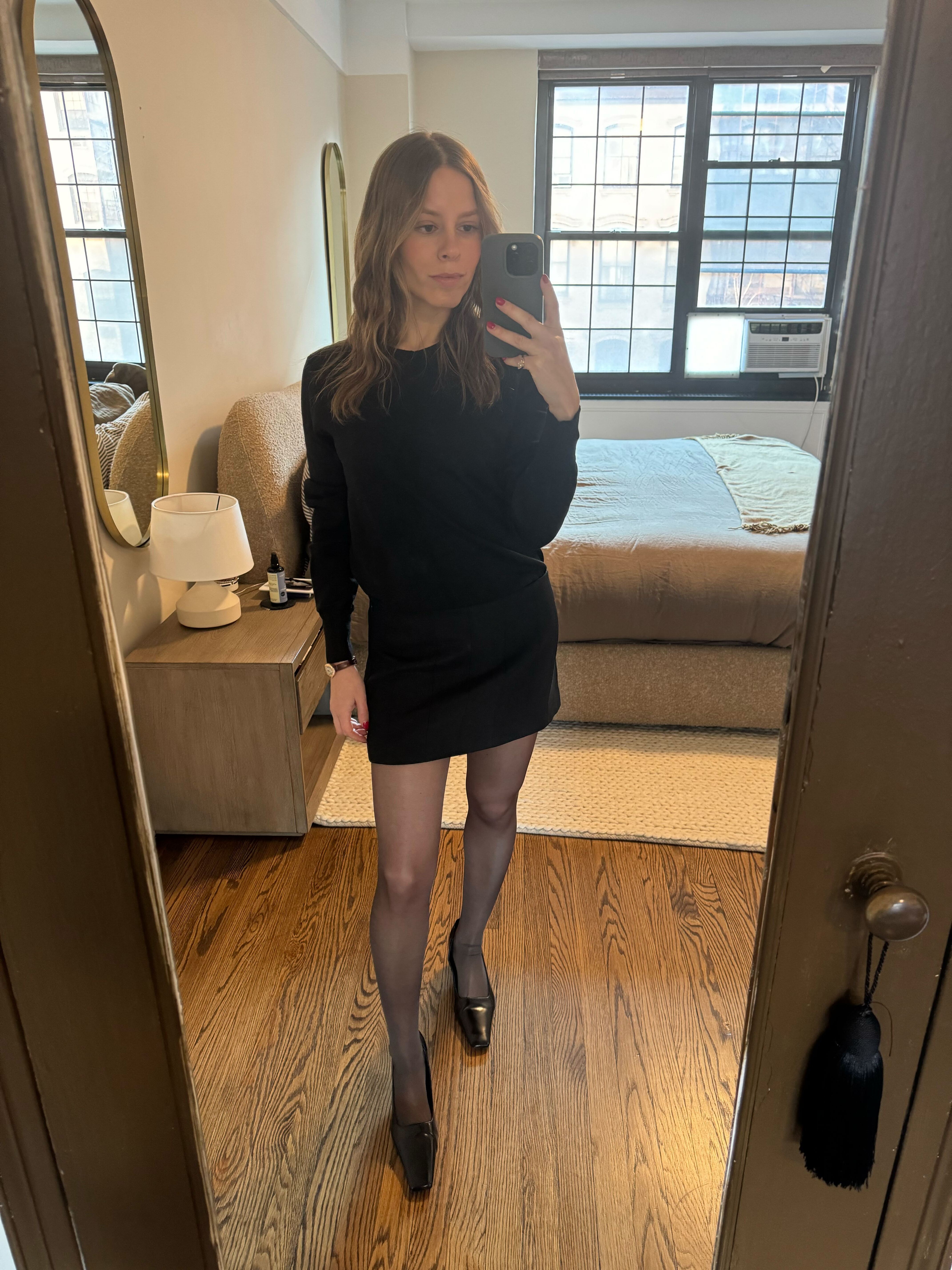 Nikki wears calzedonia sheer tights, black mini skirt, black sweater, and pumps.