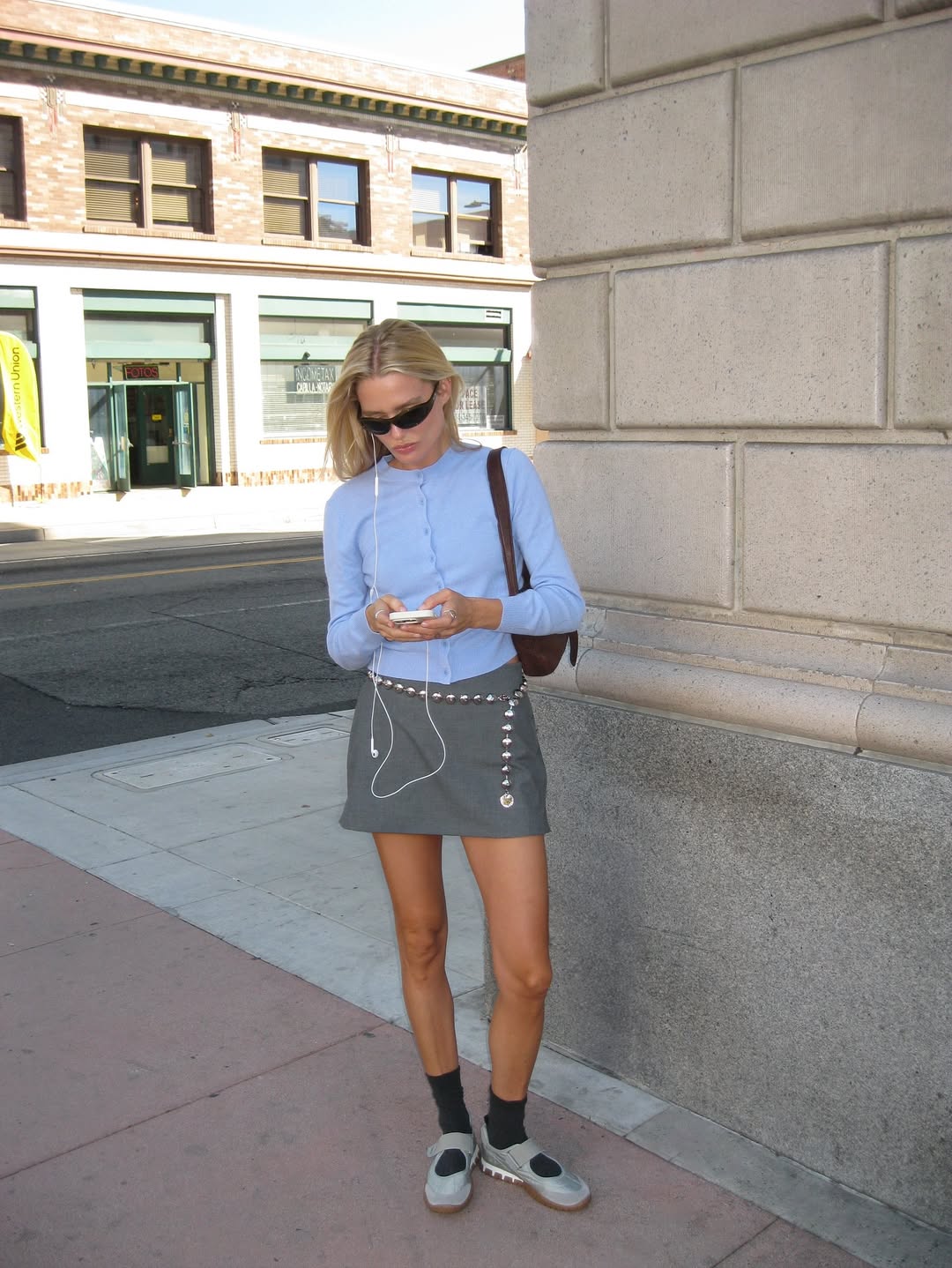 Megan Adelaide in a fitted cardigan and miniskirt.