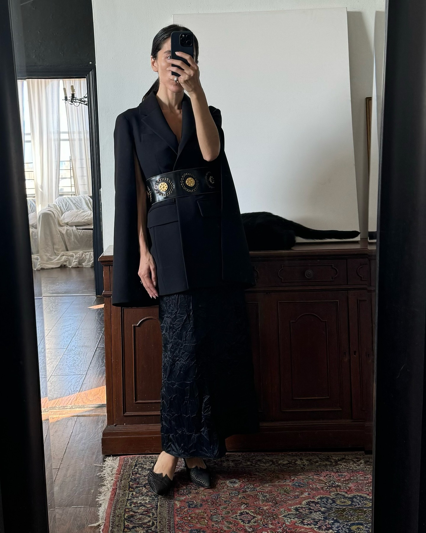 Alexis Badiyi wearing a skirt outfit idea for 2026, including a belted blazer and wrinkled satin skirt.