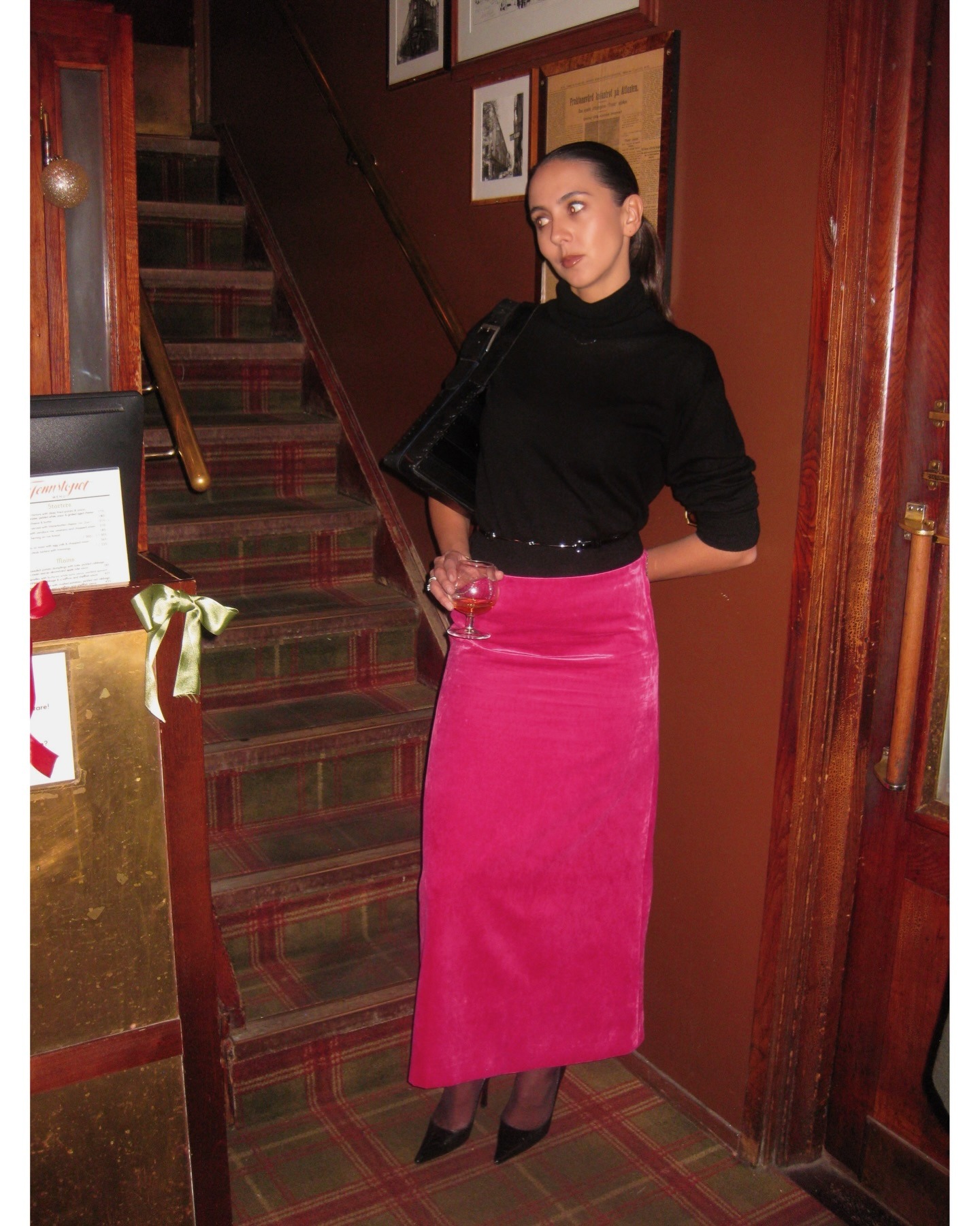 Hanna MW wearing a skirt outfit idea for 2026, including a black sweater with a pink Gucci velvet skirt.