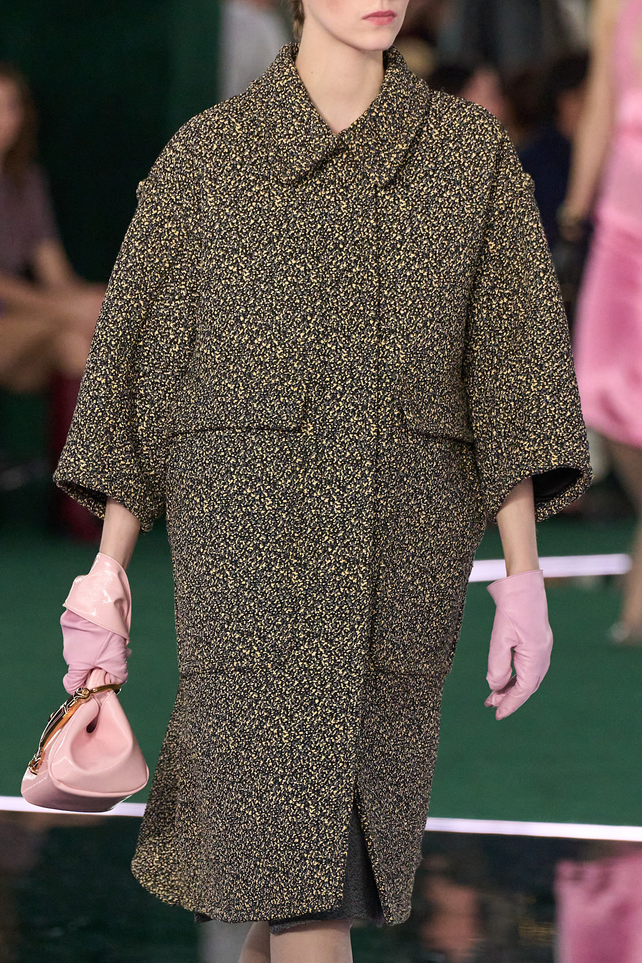 Model wearing colored gloves on the runway.