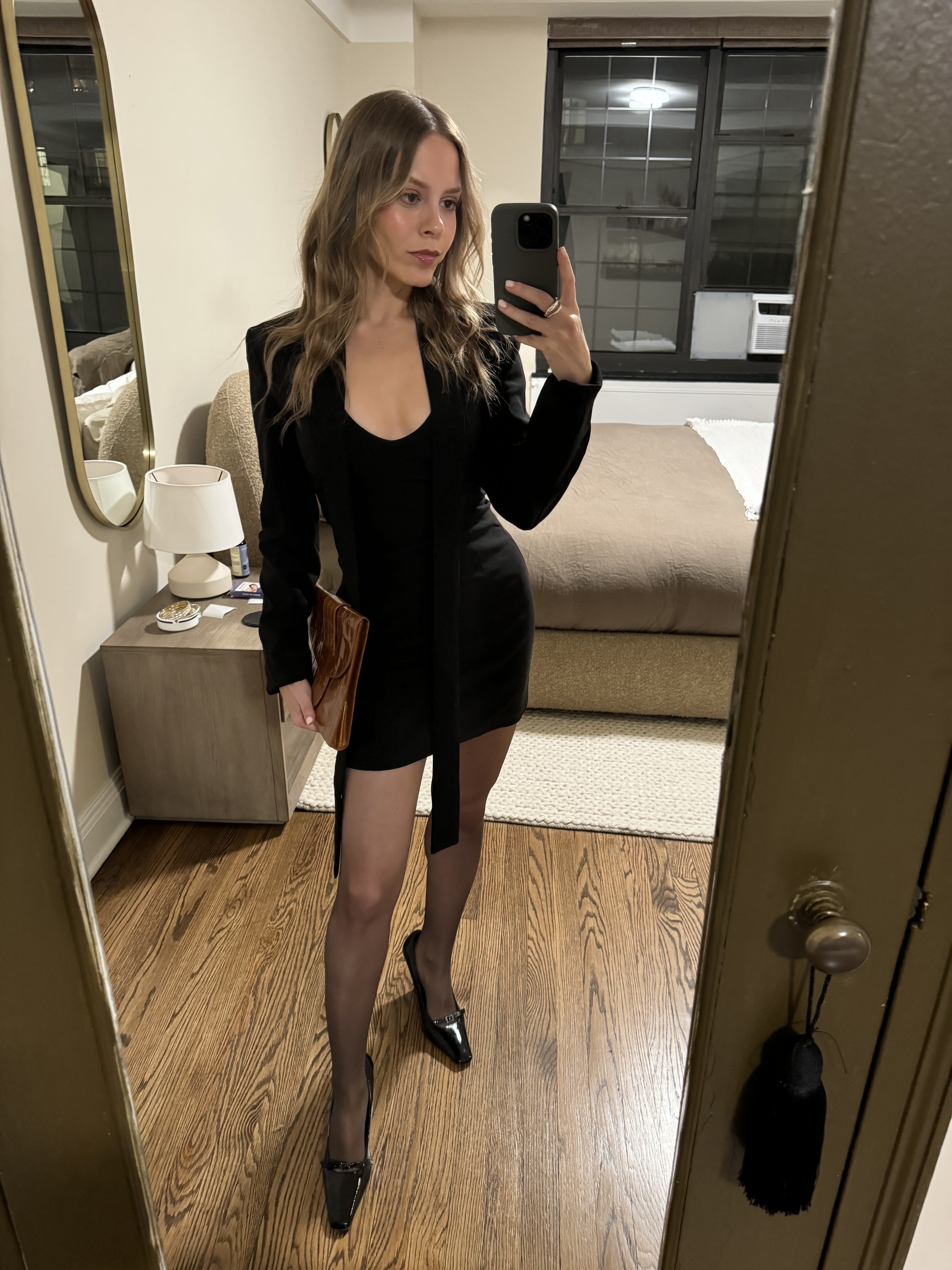 Nikki chwatt wears sheer brown wolford tights and a black minidress.