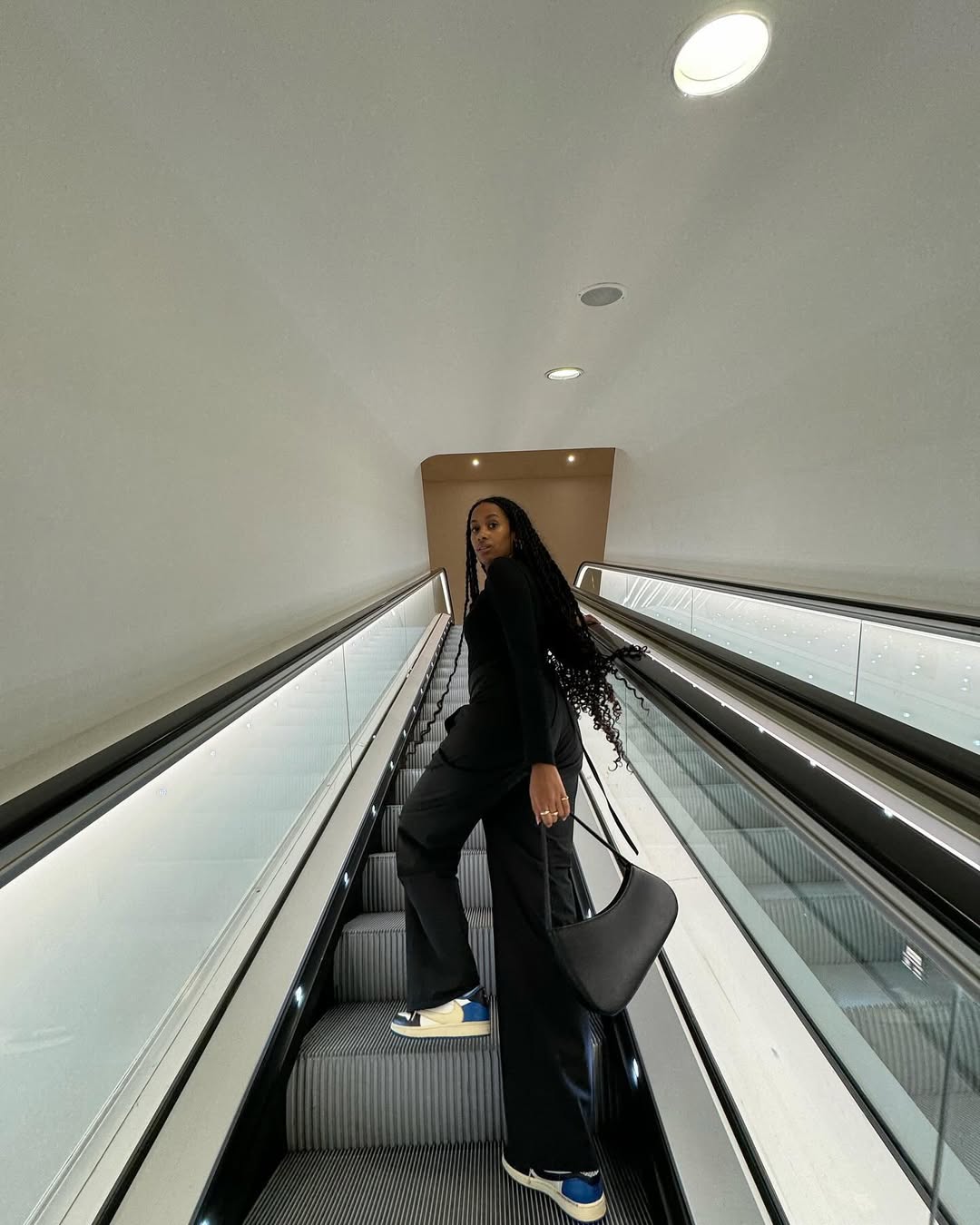 Influencer Claire Most in black wide-leg pants and colorful sneakers.