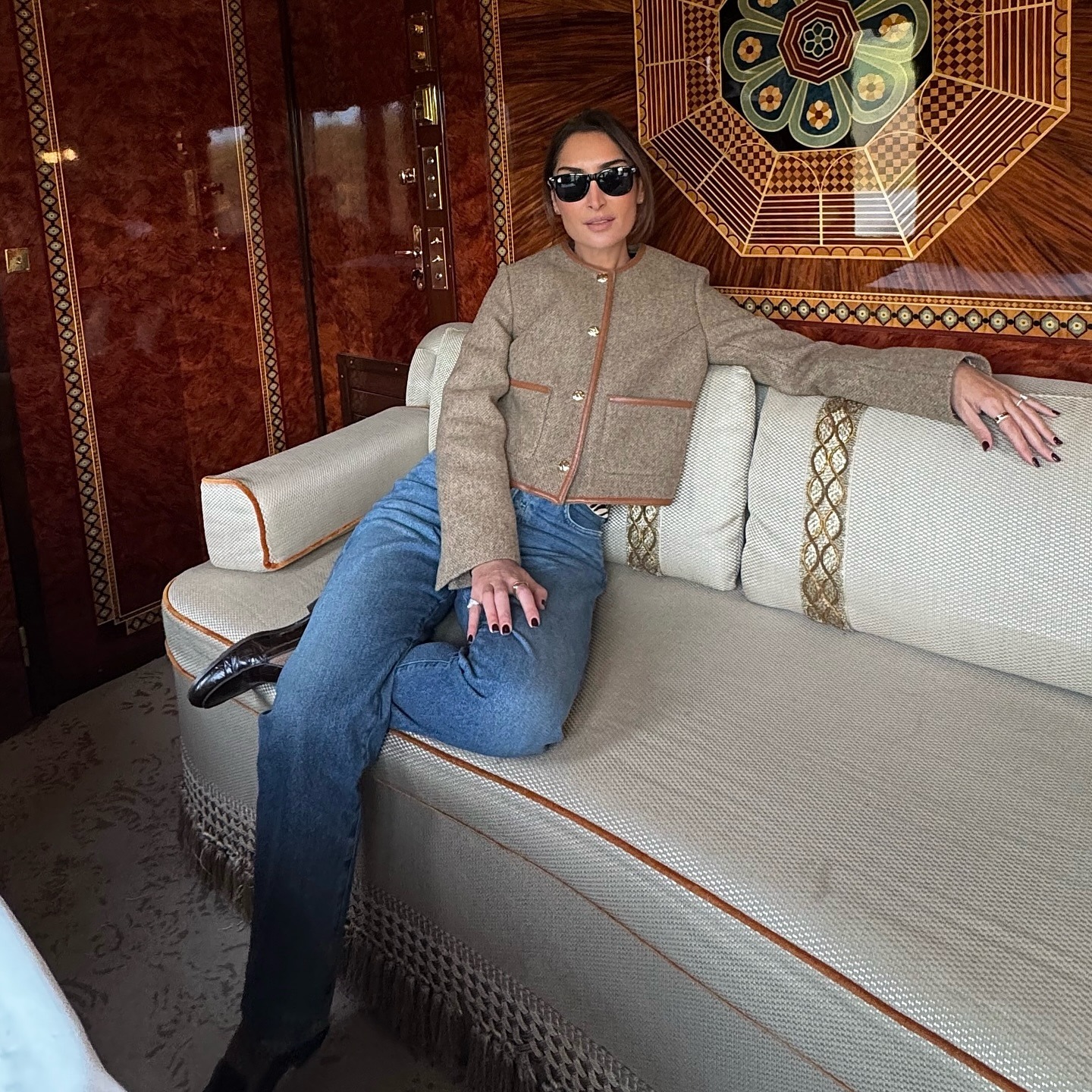 @erinoffduty wearing a lady jacket while sitting on a couch.